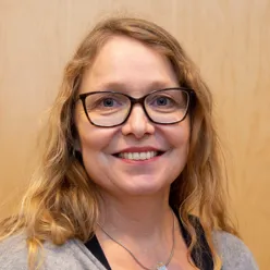 En kvinne med briller som smiler