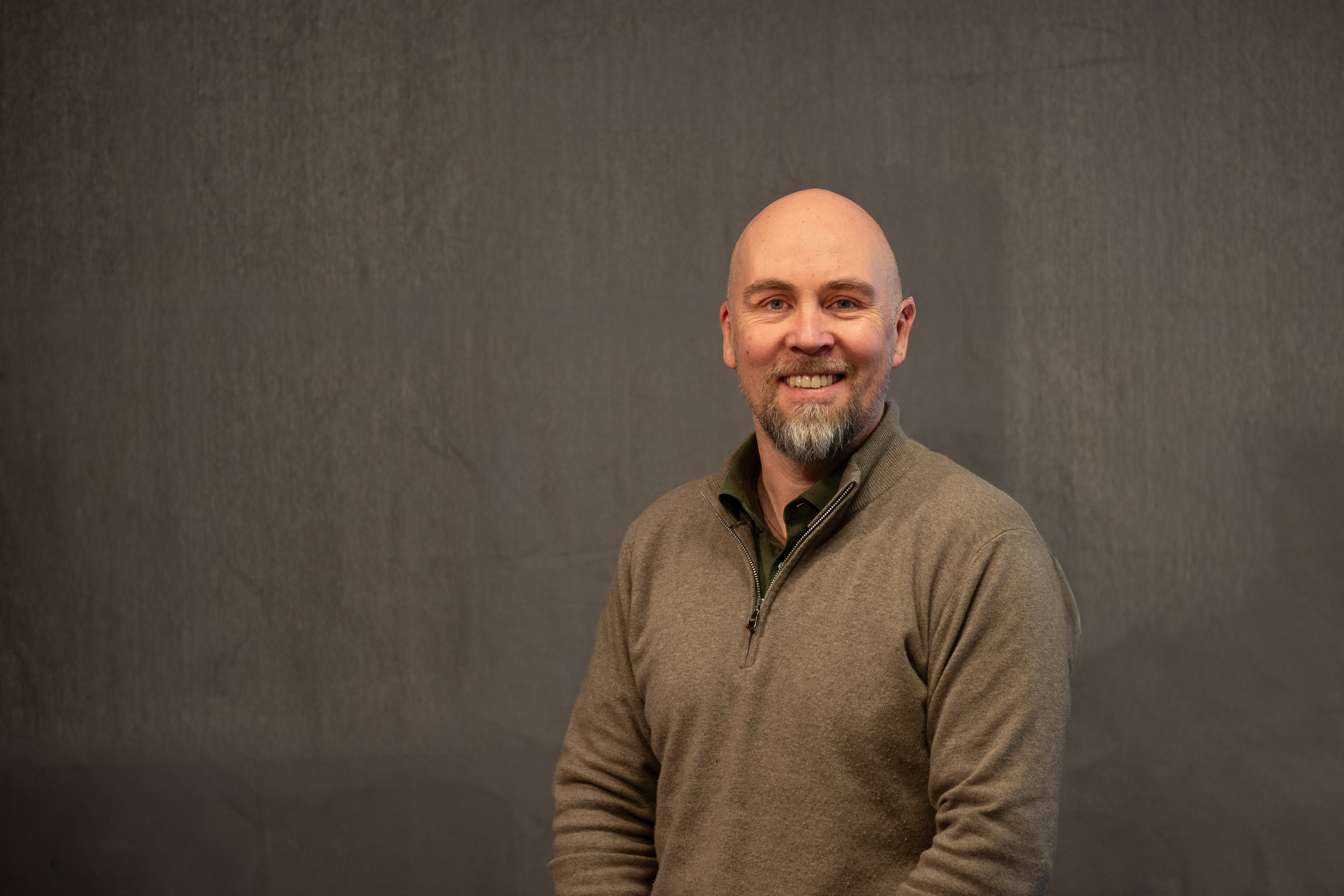 Mann med skjegg som smiler mot kamera