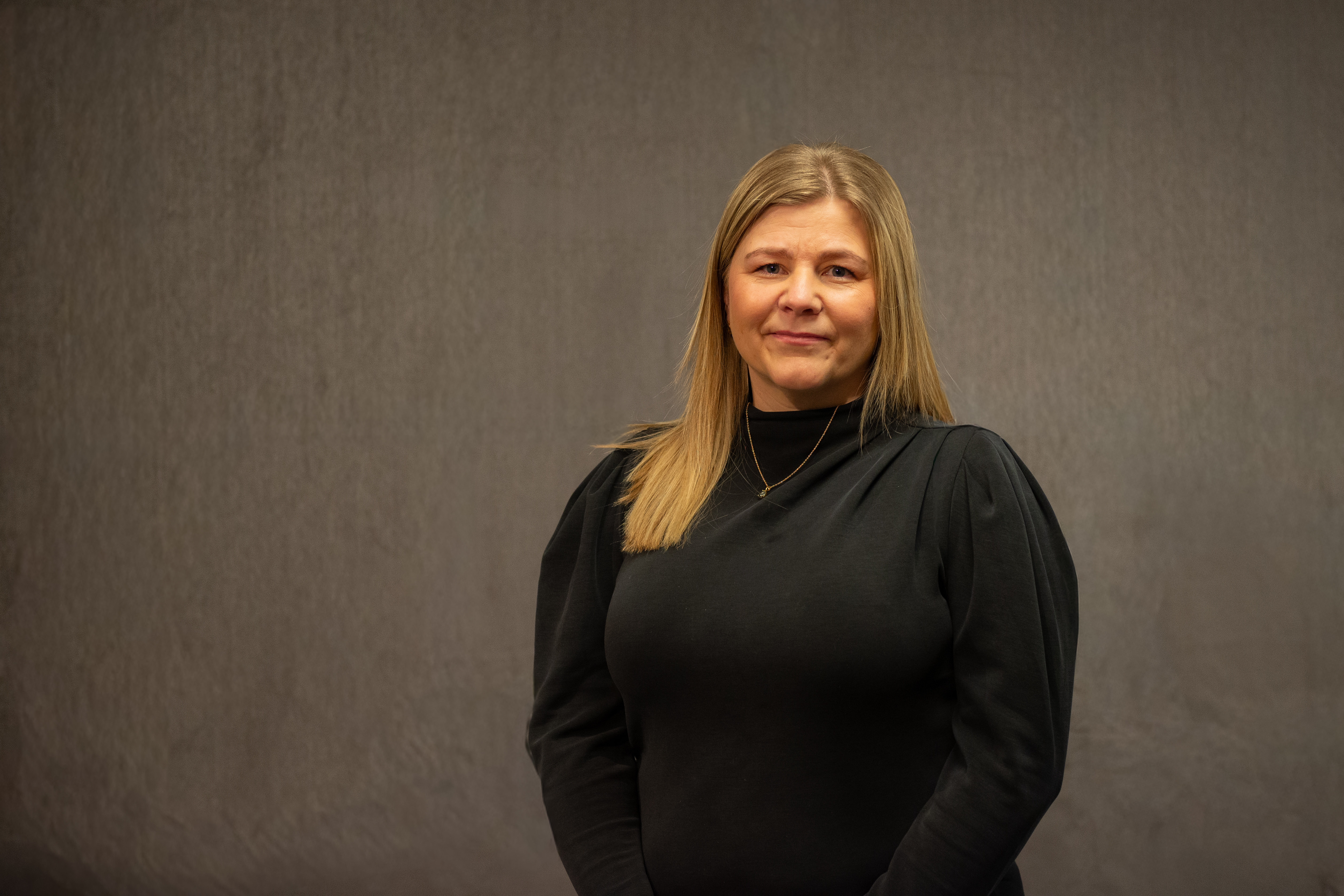 Dame med lyst hår ser inn i kamera