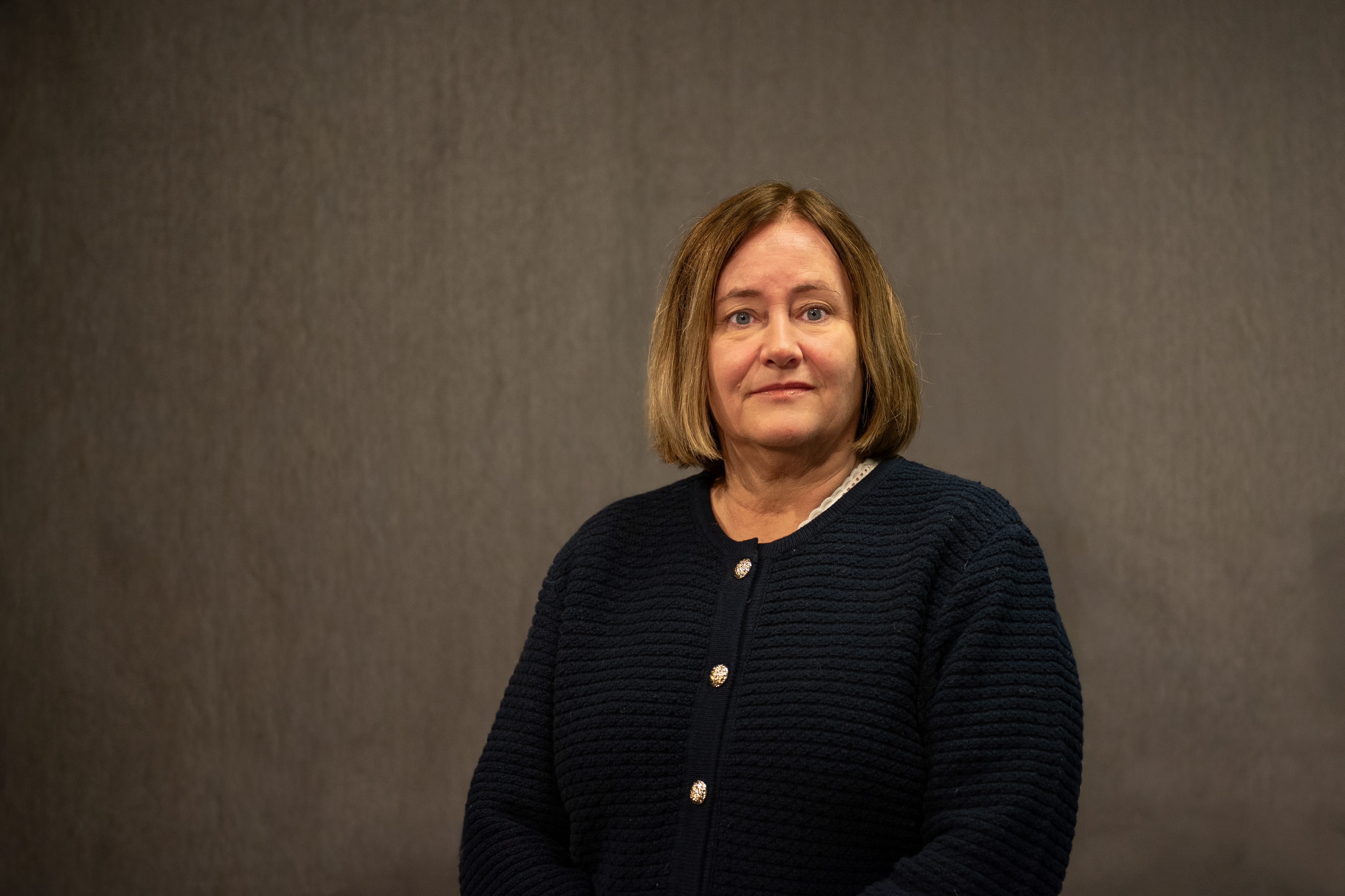 Dame med mørkt hår poserer for et portrett mens hun ser inn i kamera