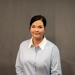 Dame med mørkt hår i hestehale poserer for et portrett mens hun ser inn i kamera