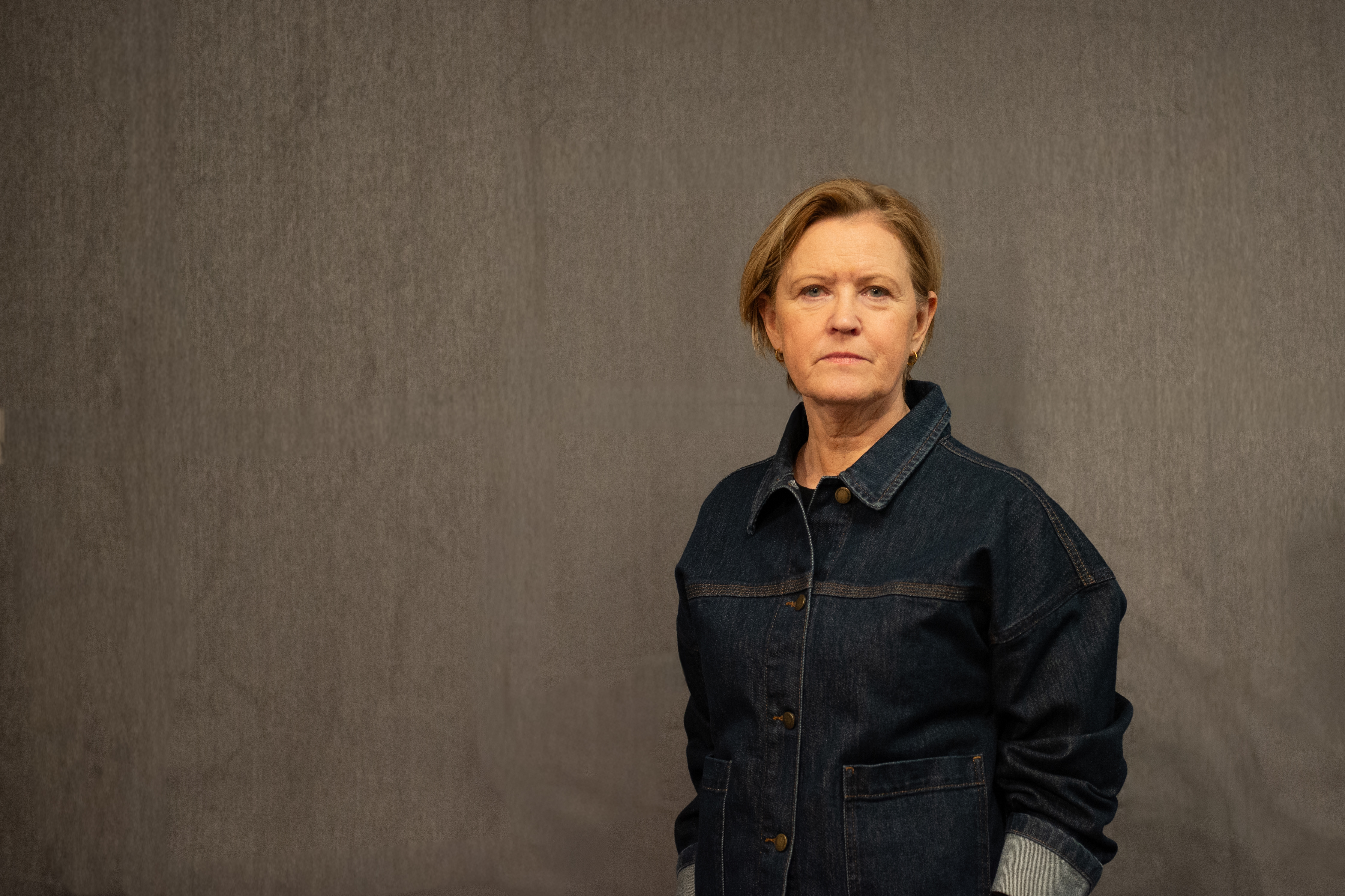 Dame med lyst hår poserer for et portrett mens hun ser inn i kamera