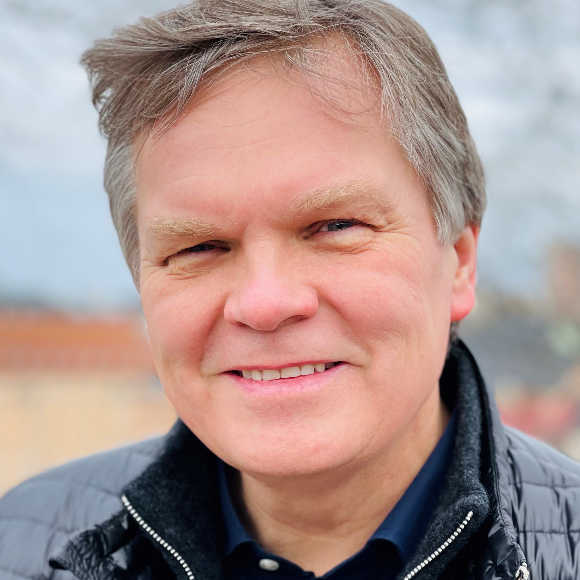 En mann som smiler til kameraet