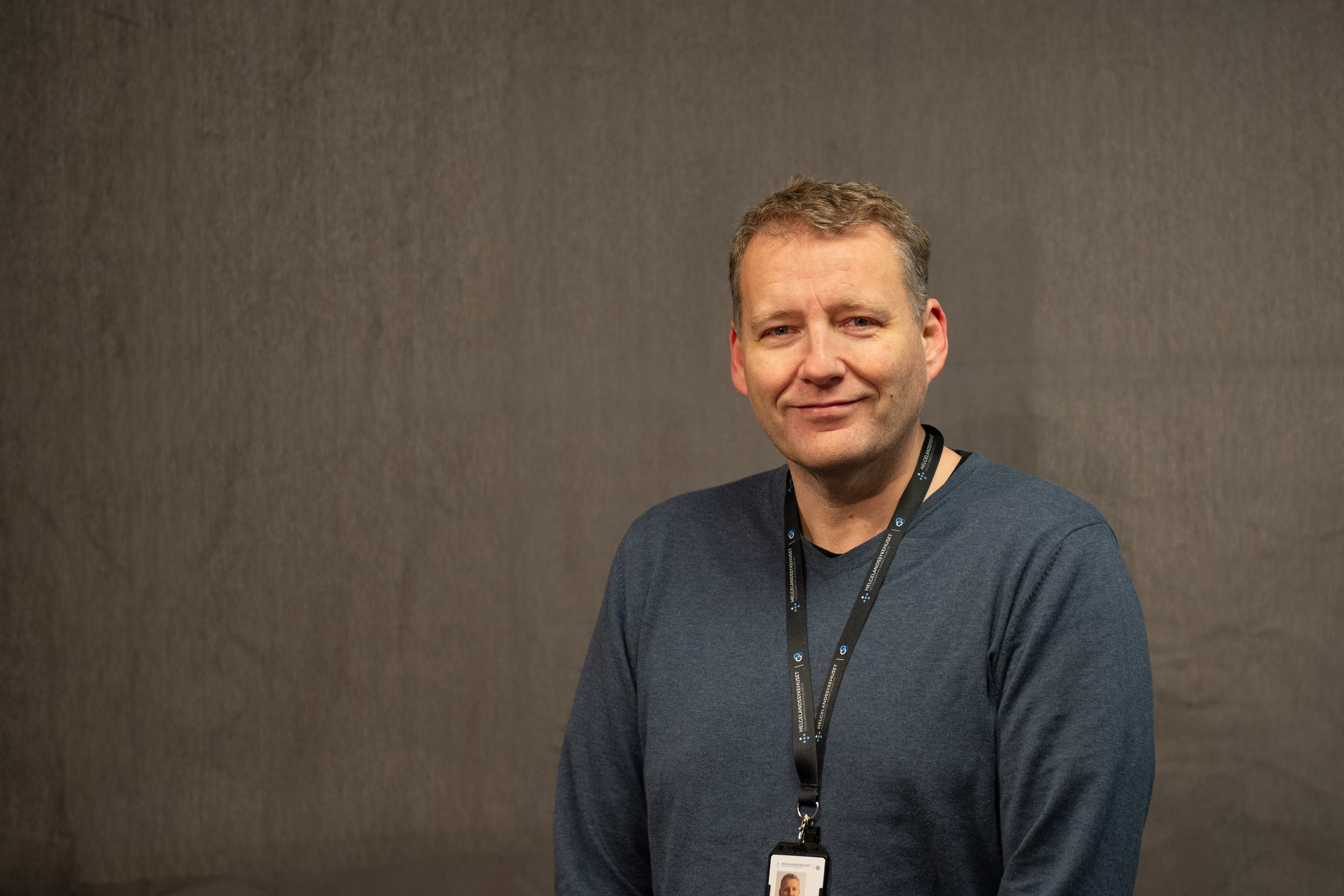 Portrettbilde av mann med kort hår som ser inn i kamera