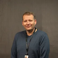 Portrettbilde av mann med kort hår som ser inn i kamera