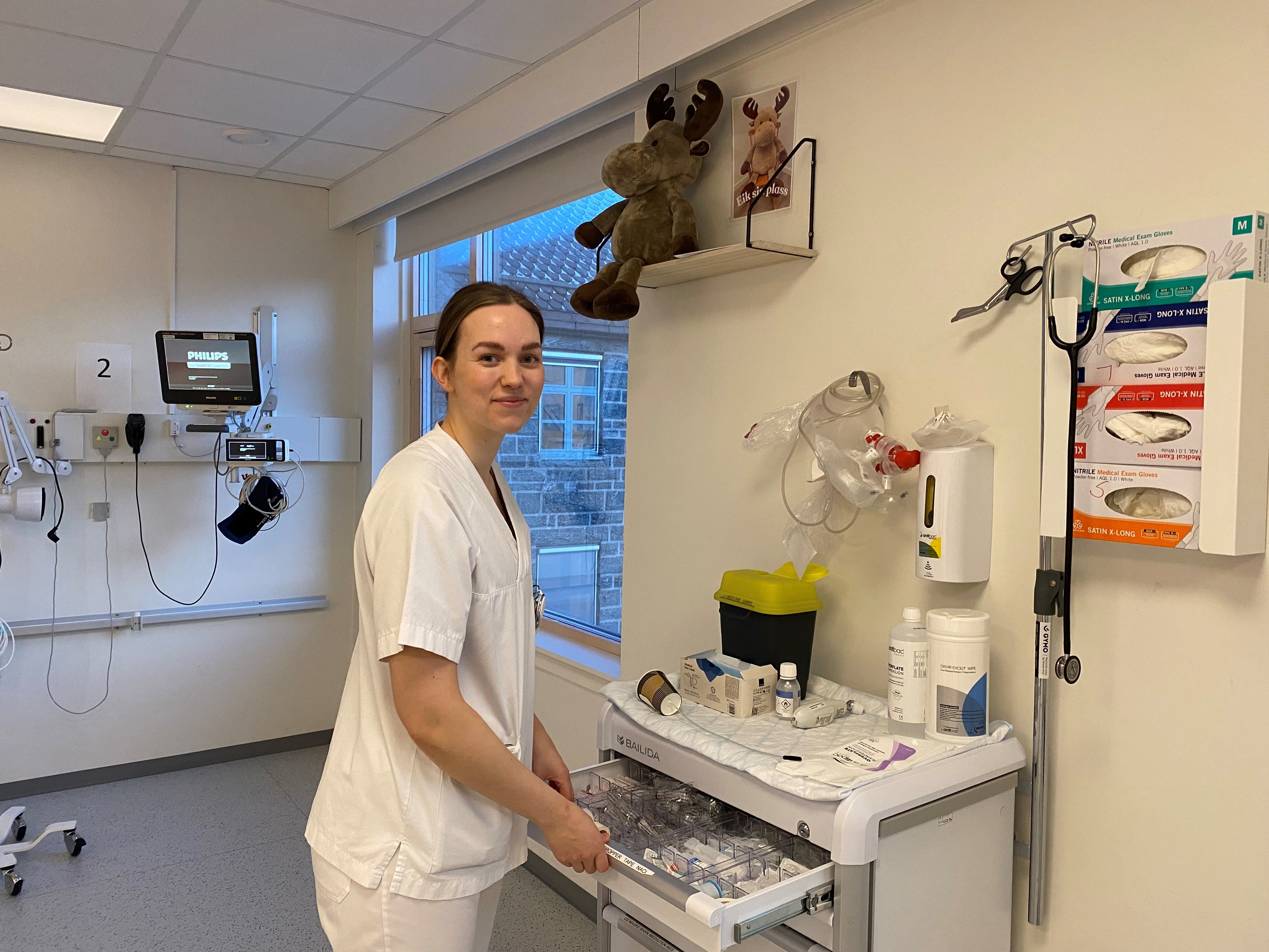 En person i sykehusklær som står ved siden av en maskin