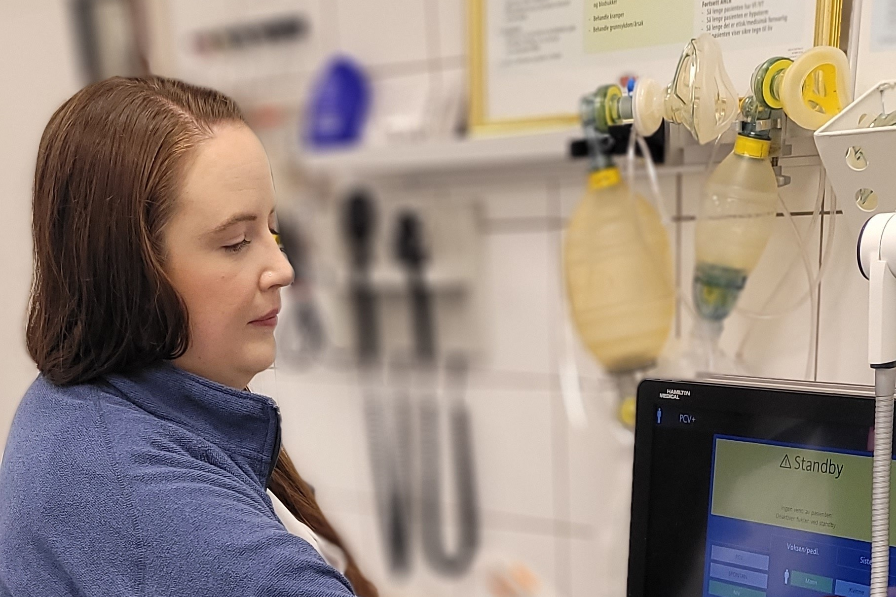 En dame i blå jakke justerer et apparat