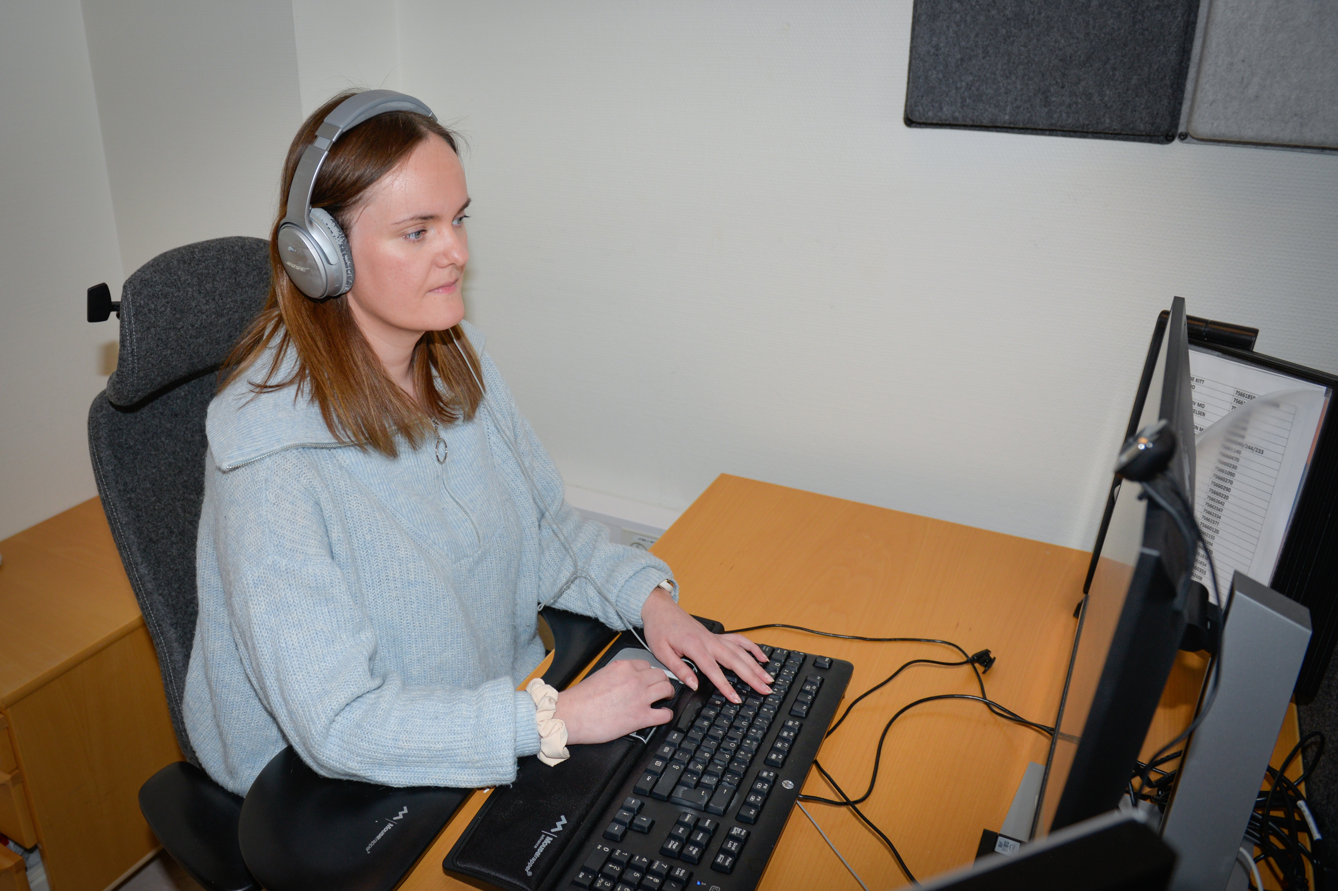 Dame som sitter og jobber foran pc-en