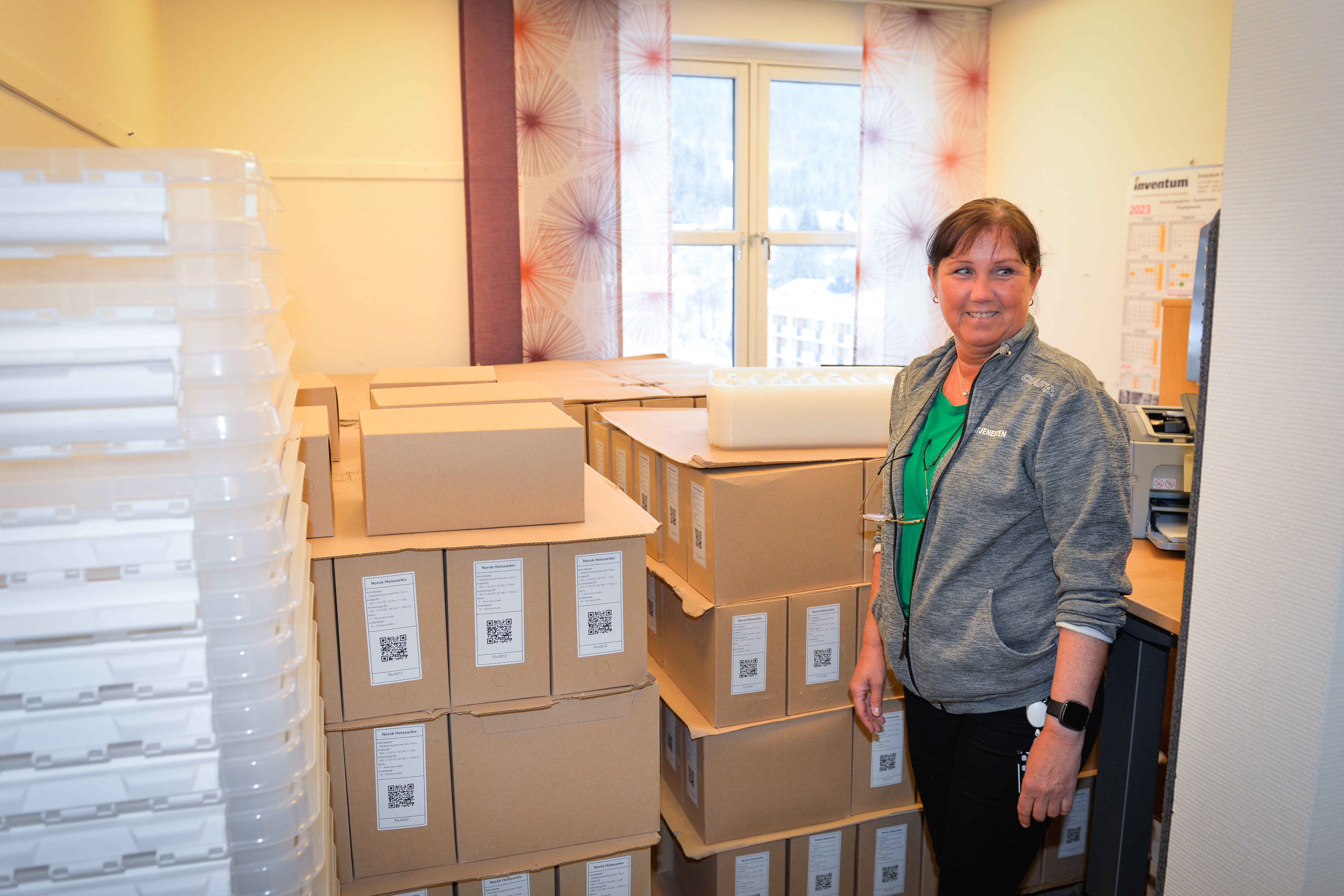 Dame står i et rom full av pappesker