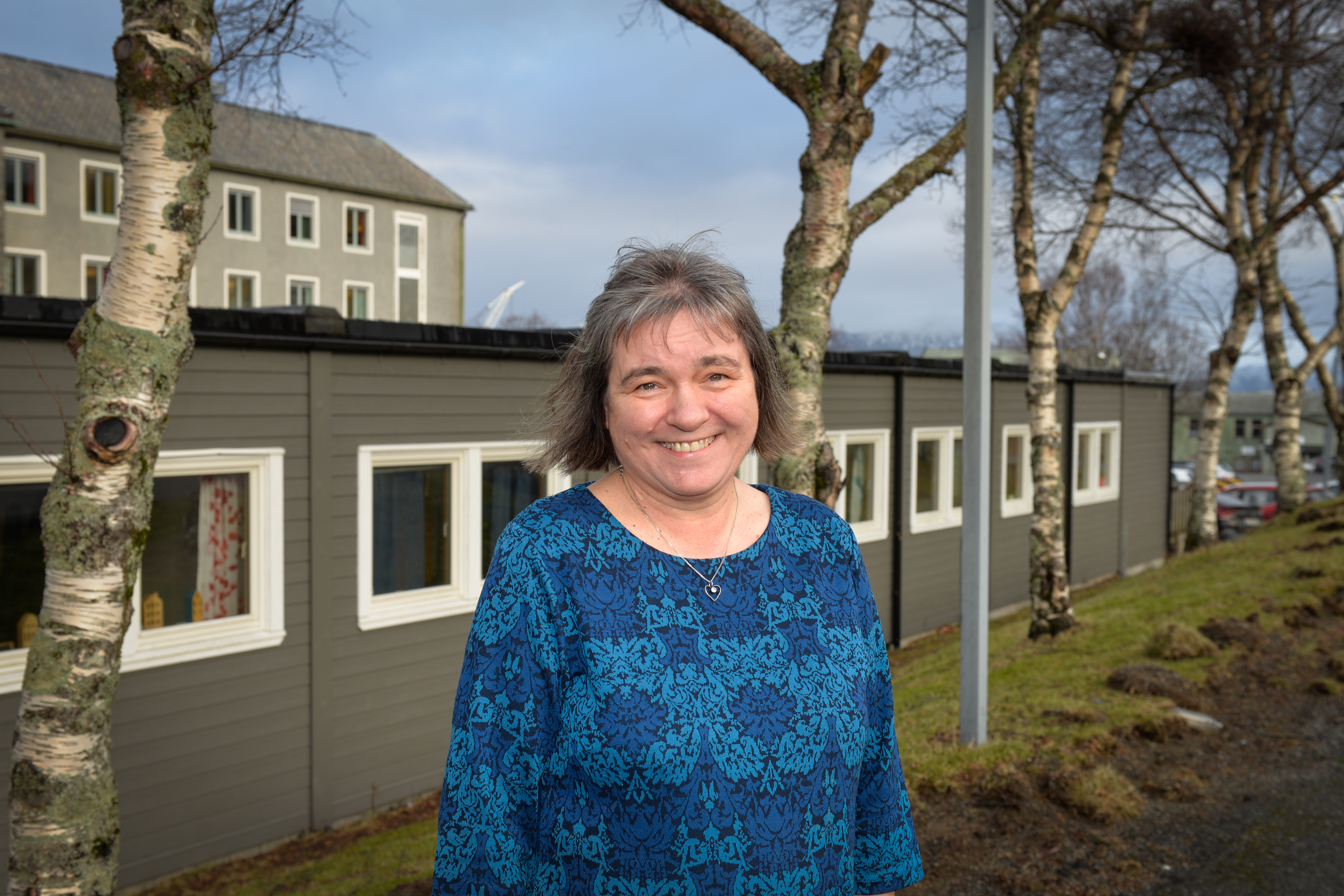 En dame står ute og smiler mot kameraet