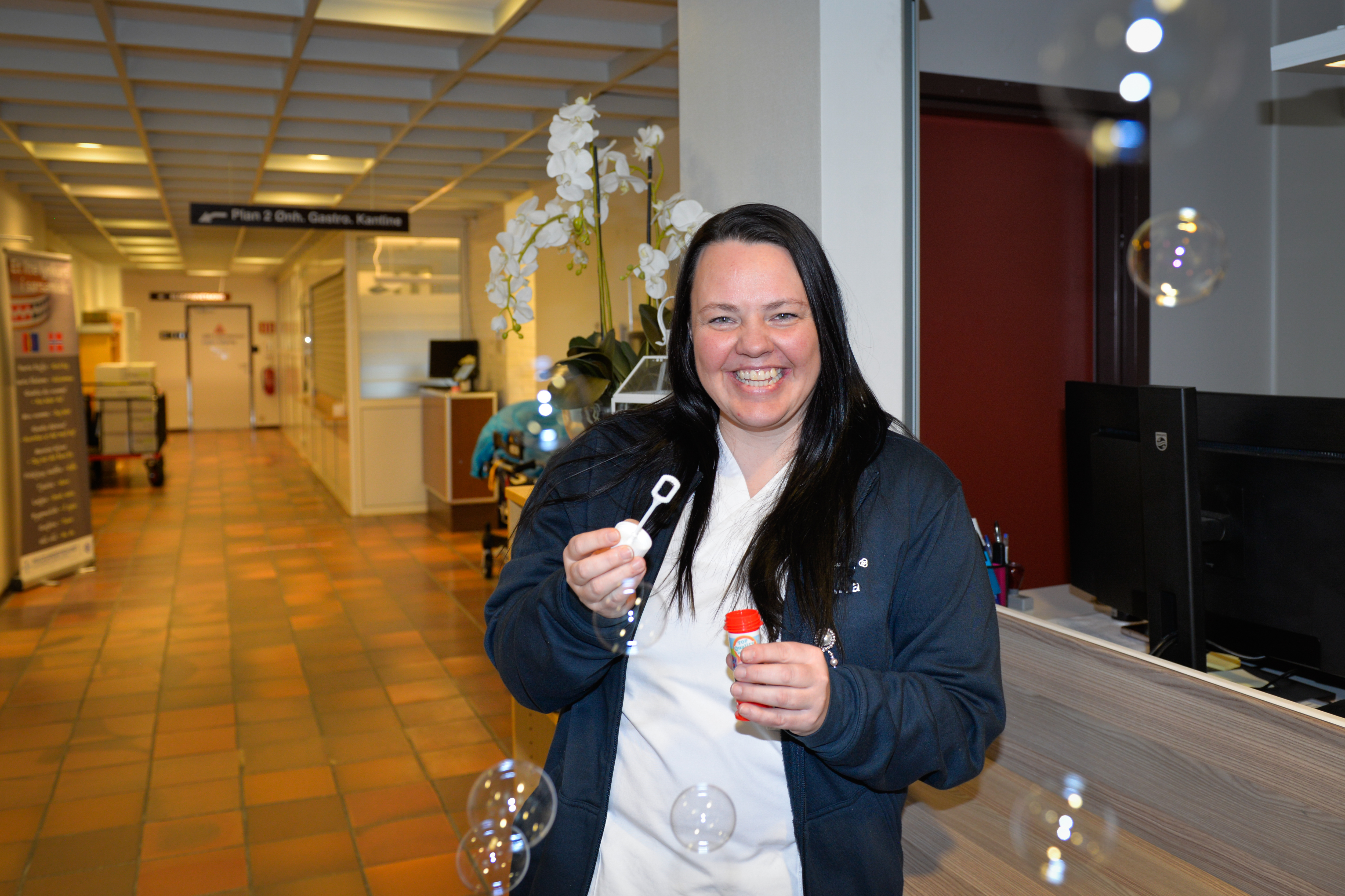 En dame blåser såpebobler og ler