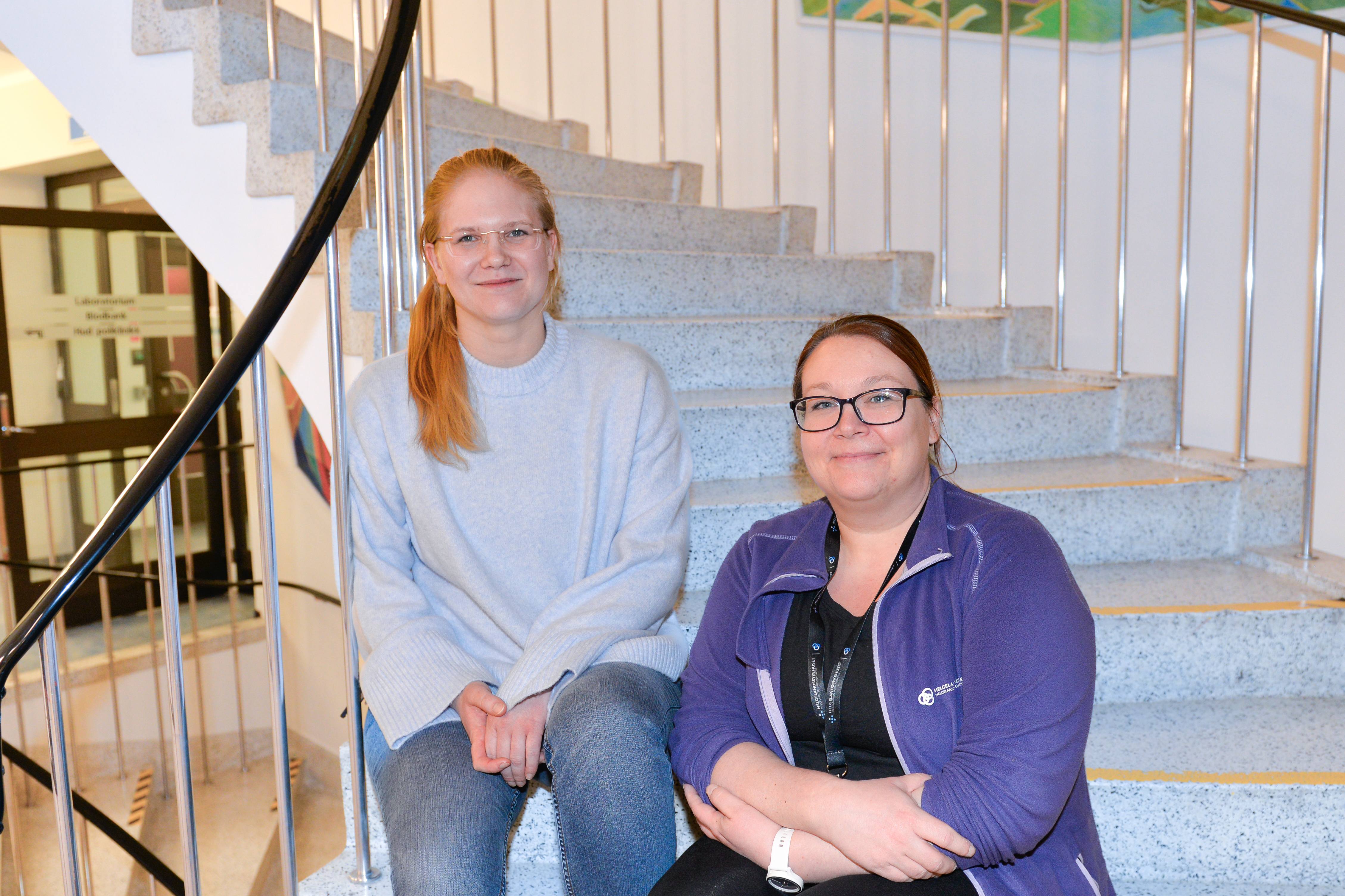 To damer sitter i ei trapp