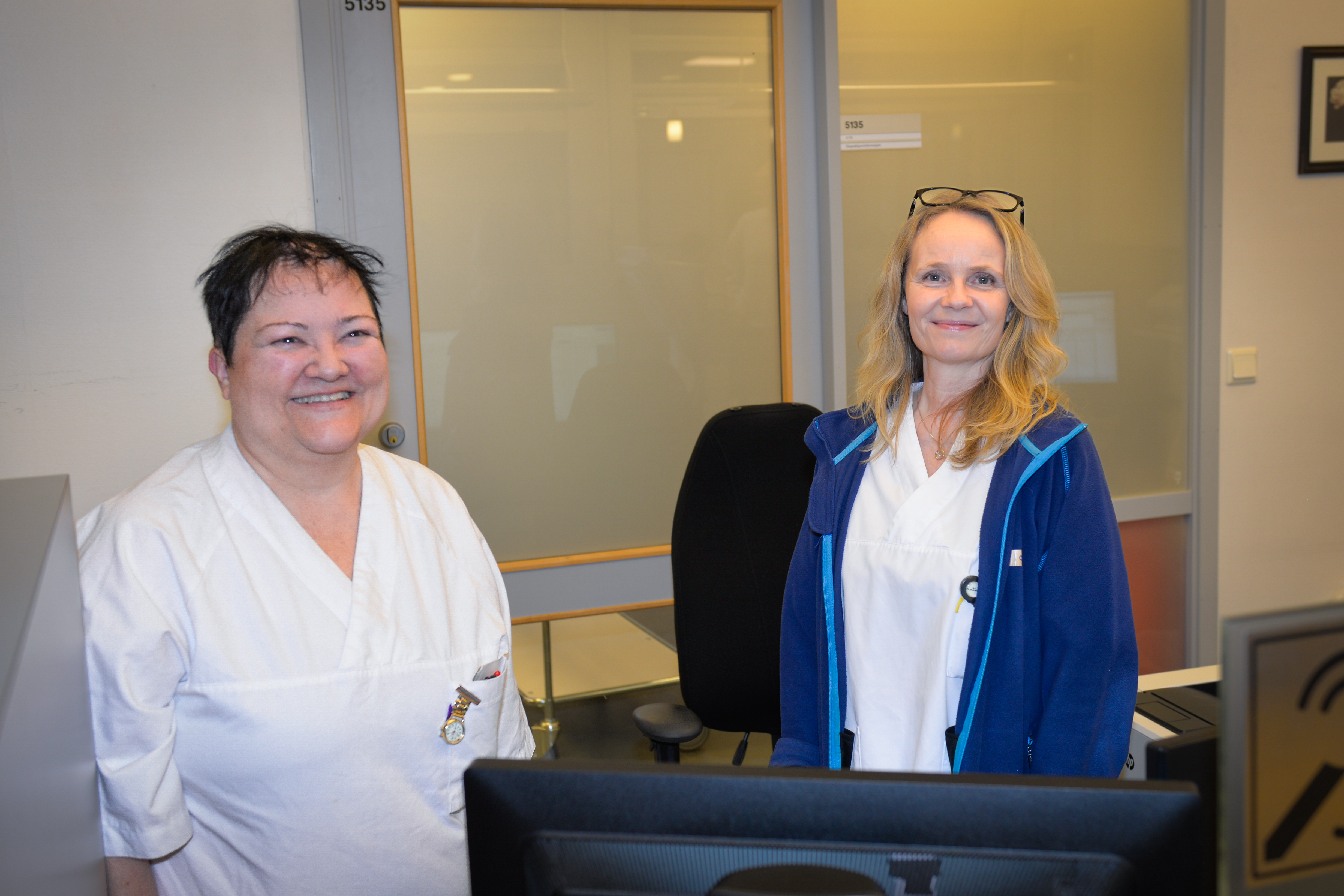 To smilende damer i sykehusklær