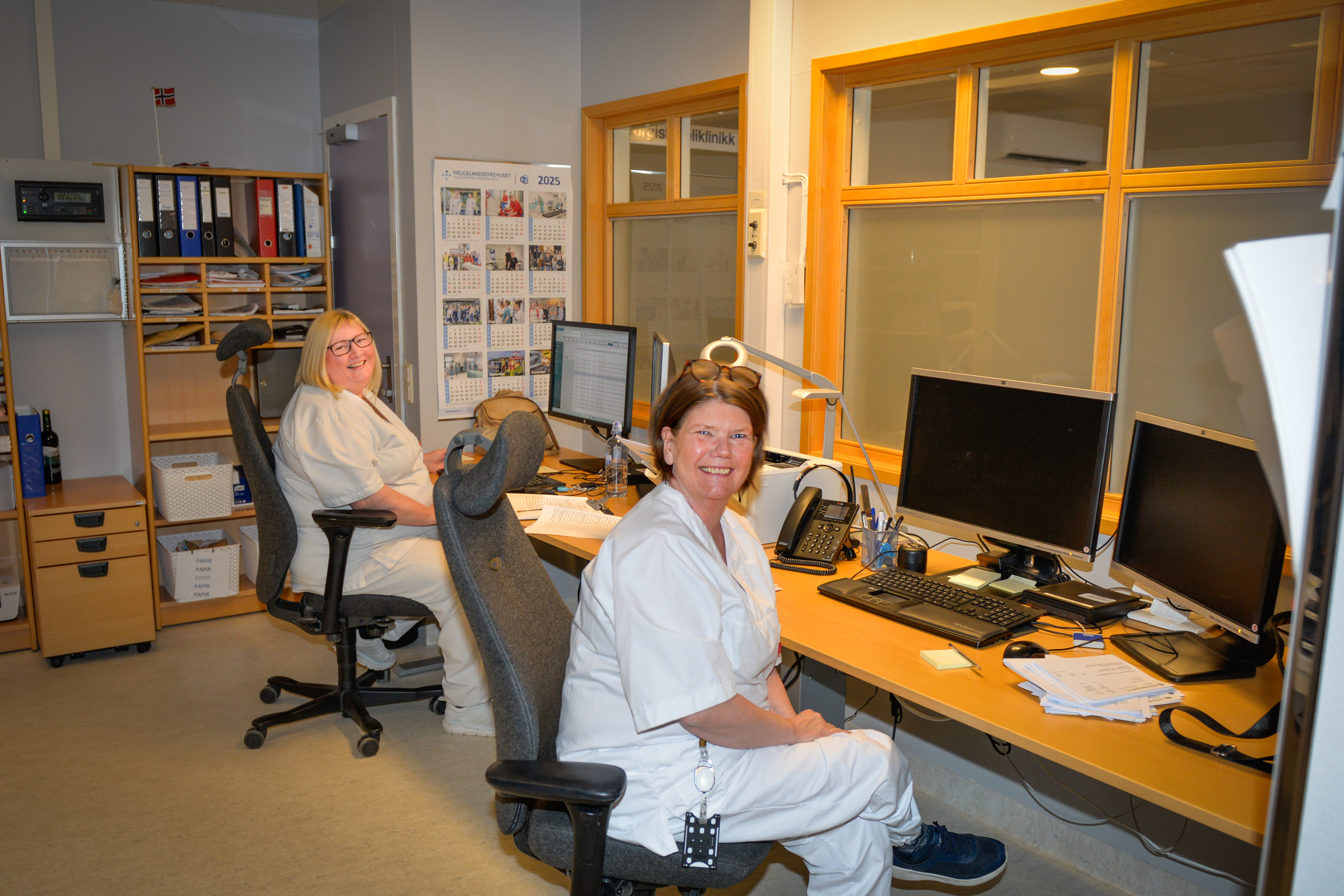 To smilende damer i hvite klær