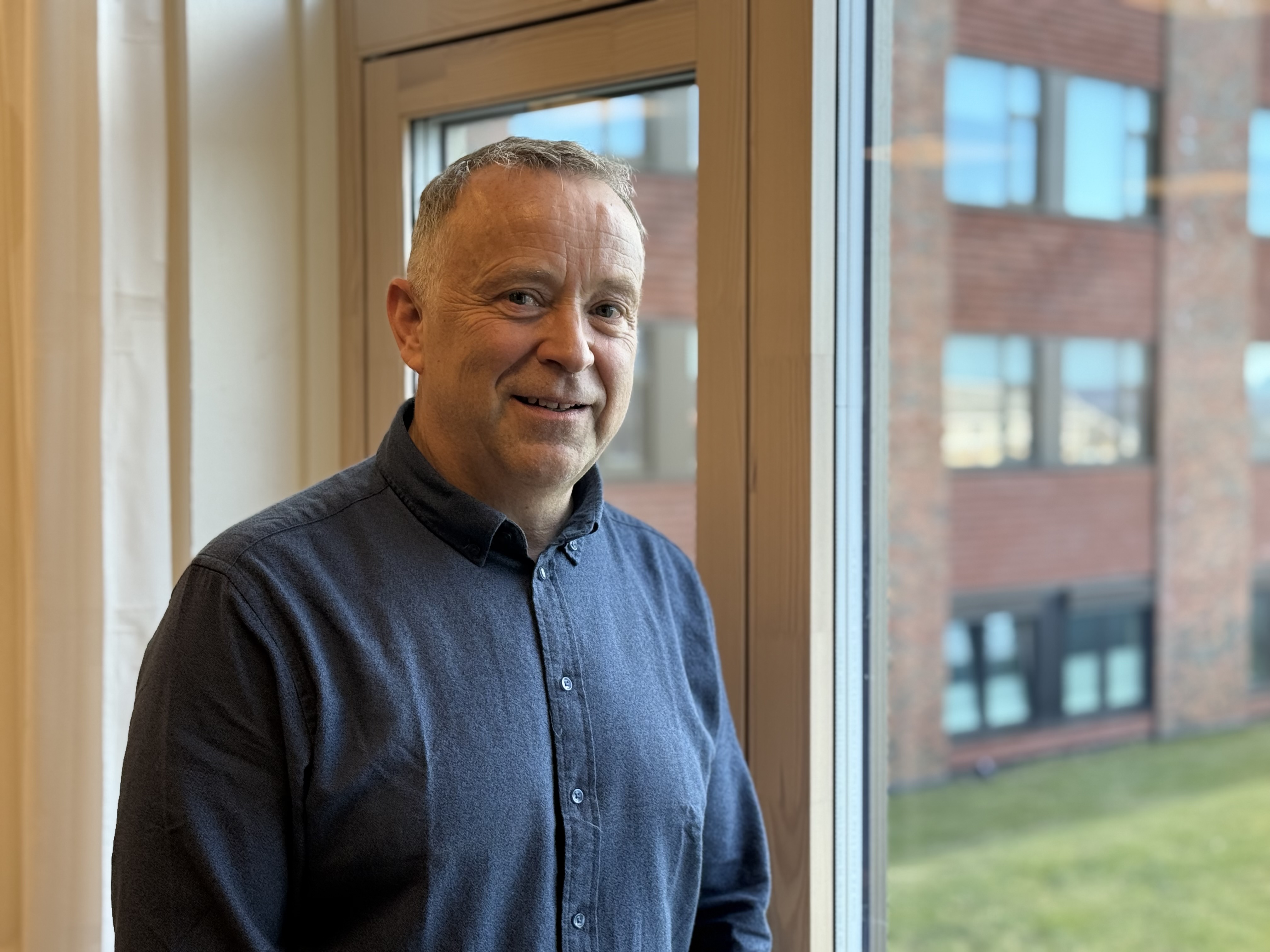 En mann som står foran et vindu