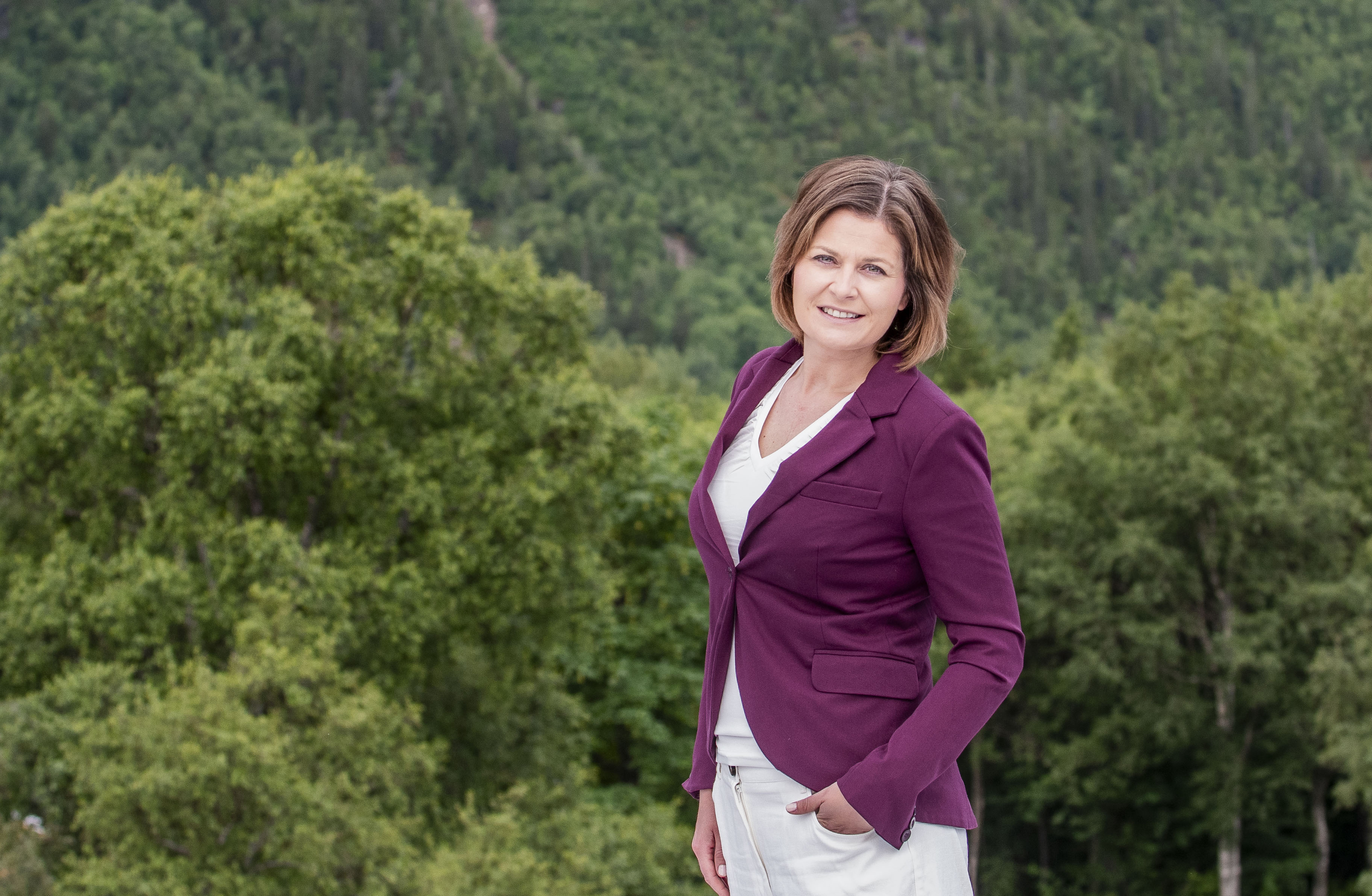 En dame som står foran en skog