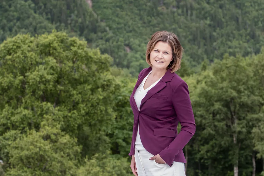 En dame som står foran en skog