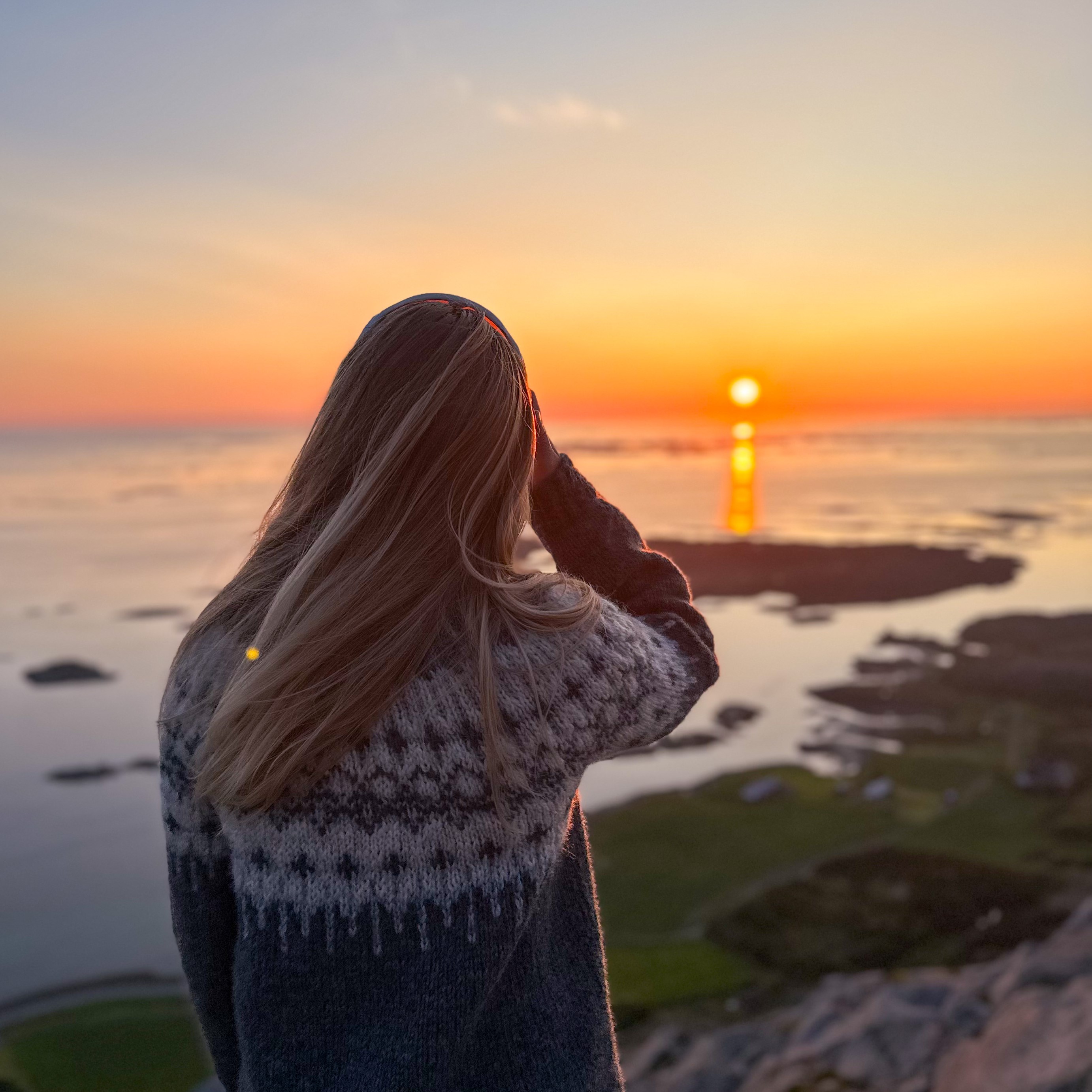 Et kvinnehode med en solnedgang i bakgrunnen