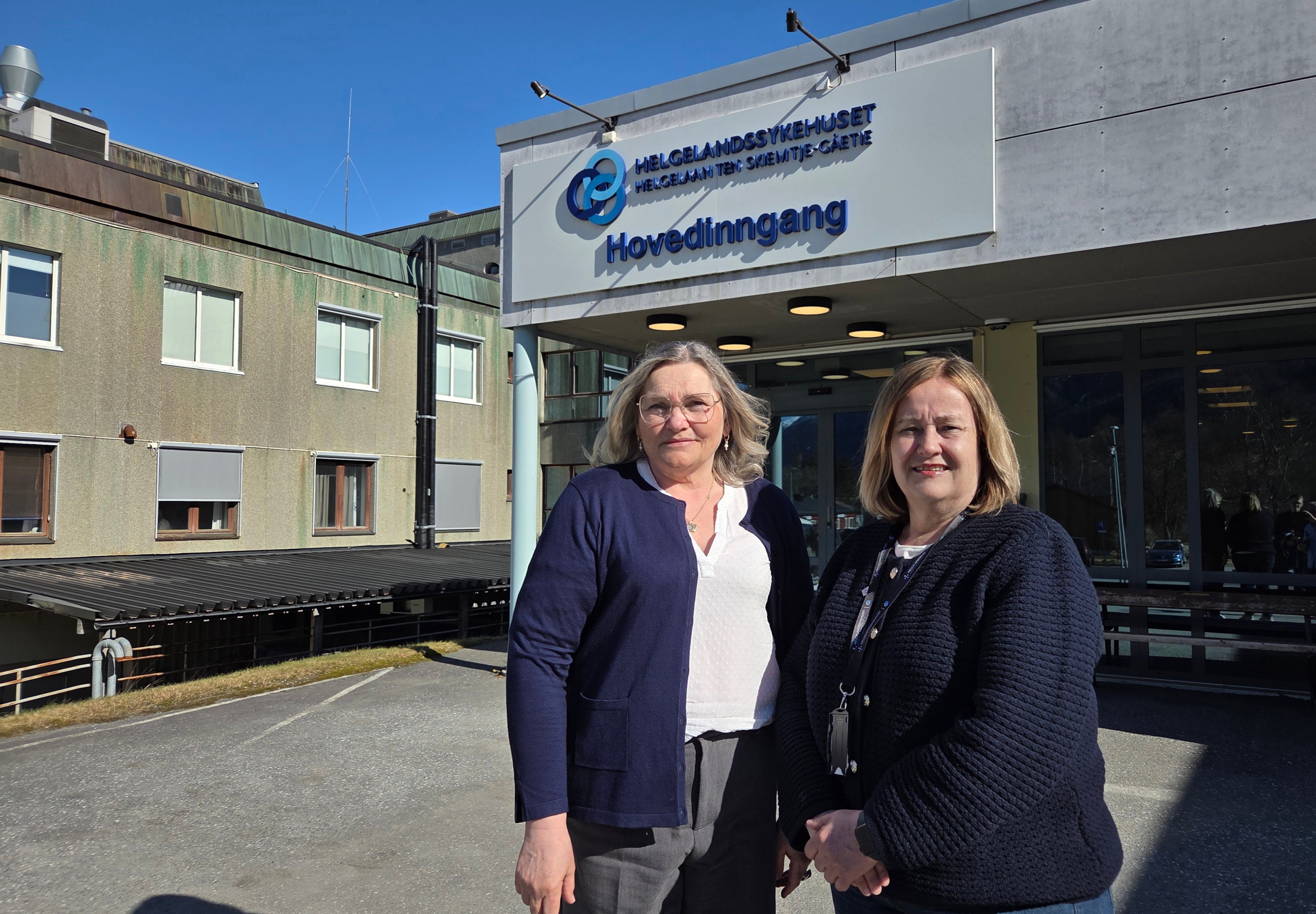 Et par kvinner som poserer for et bilde utenfor en bygning