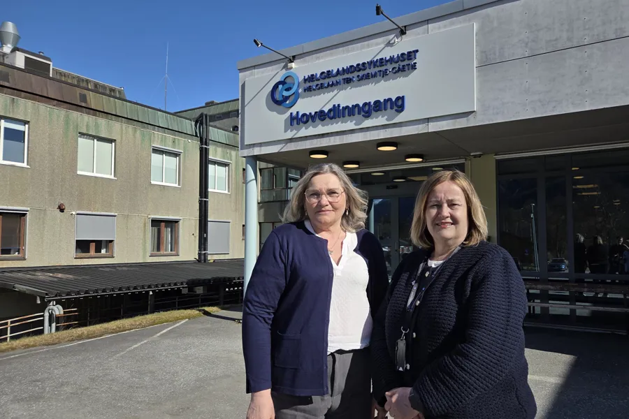 Et par kvinner som poserer for et bilde utenfor en bygning