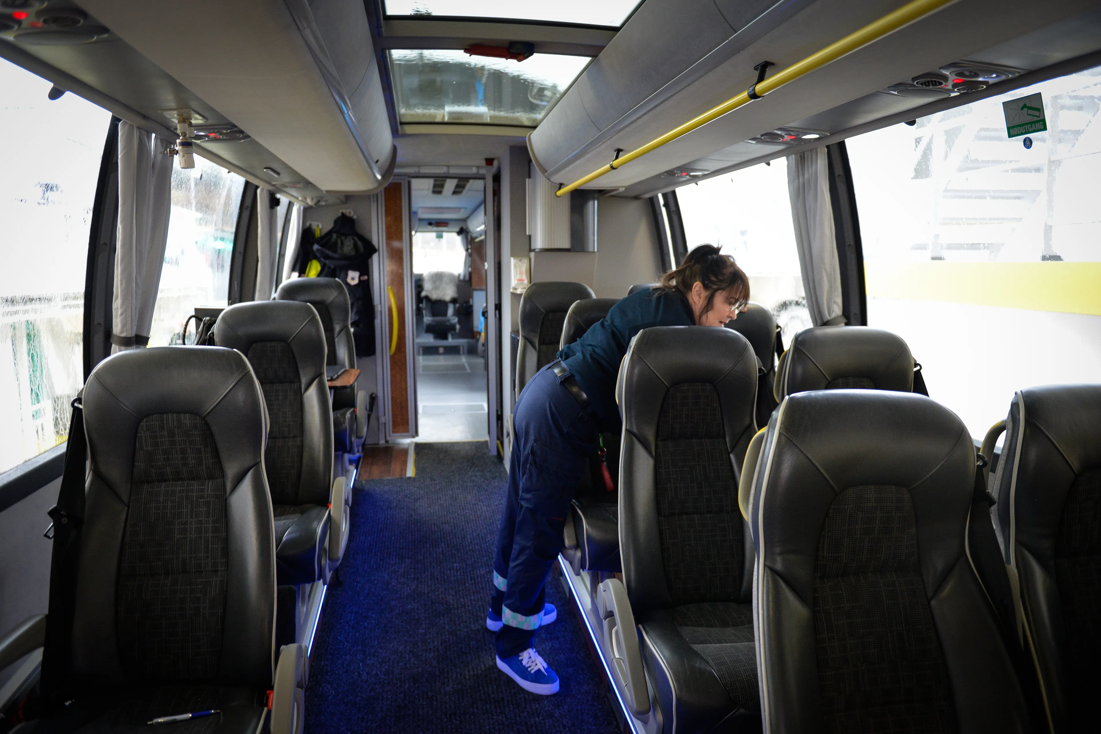 Dame vasker over bord i en buss