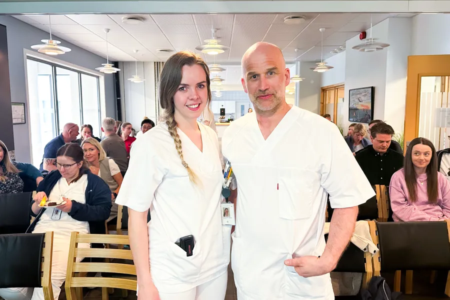 Smilende dame og mann i hvite klær