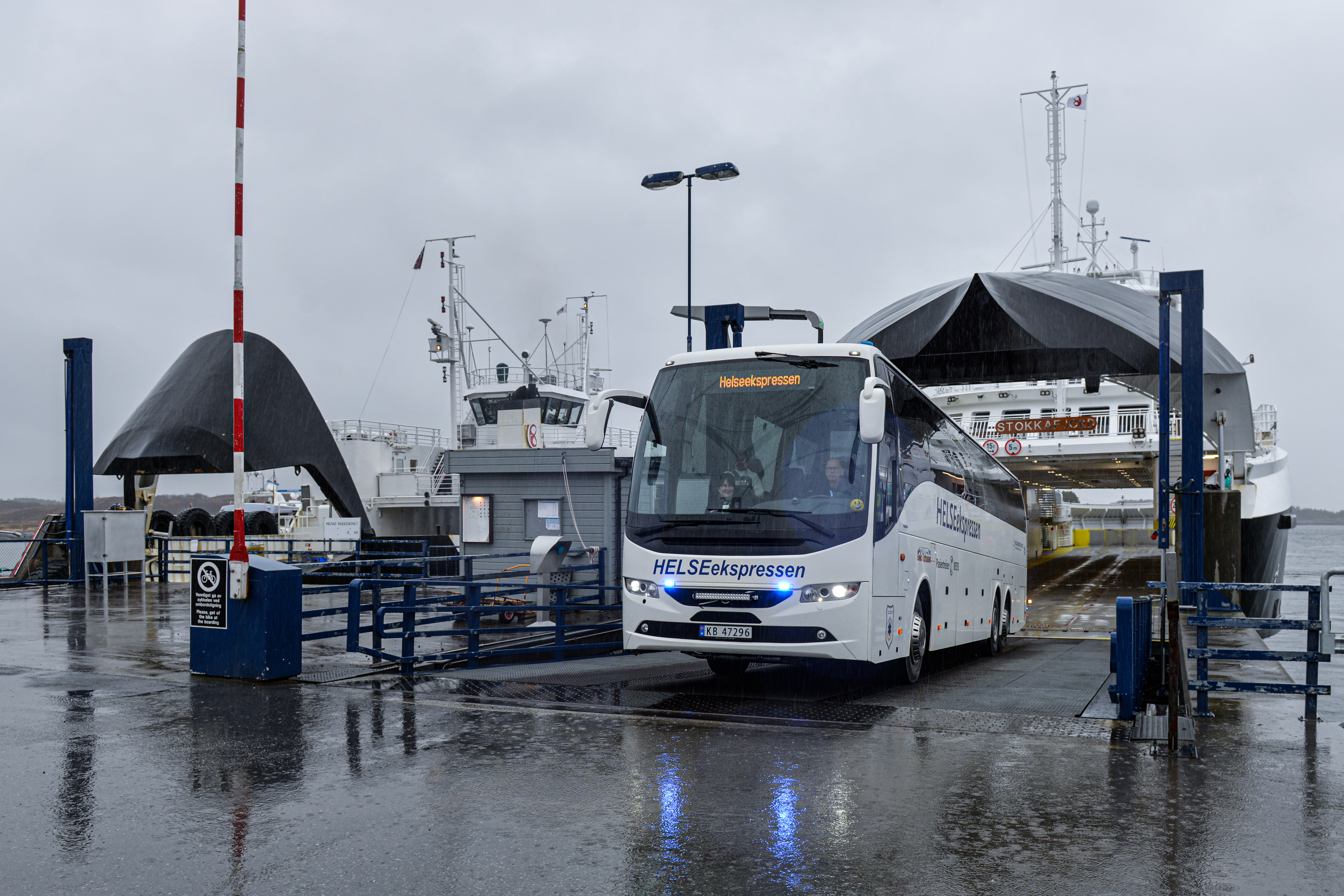 Buss kjører av ferga med blålys på