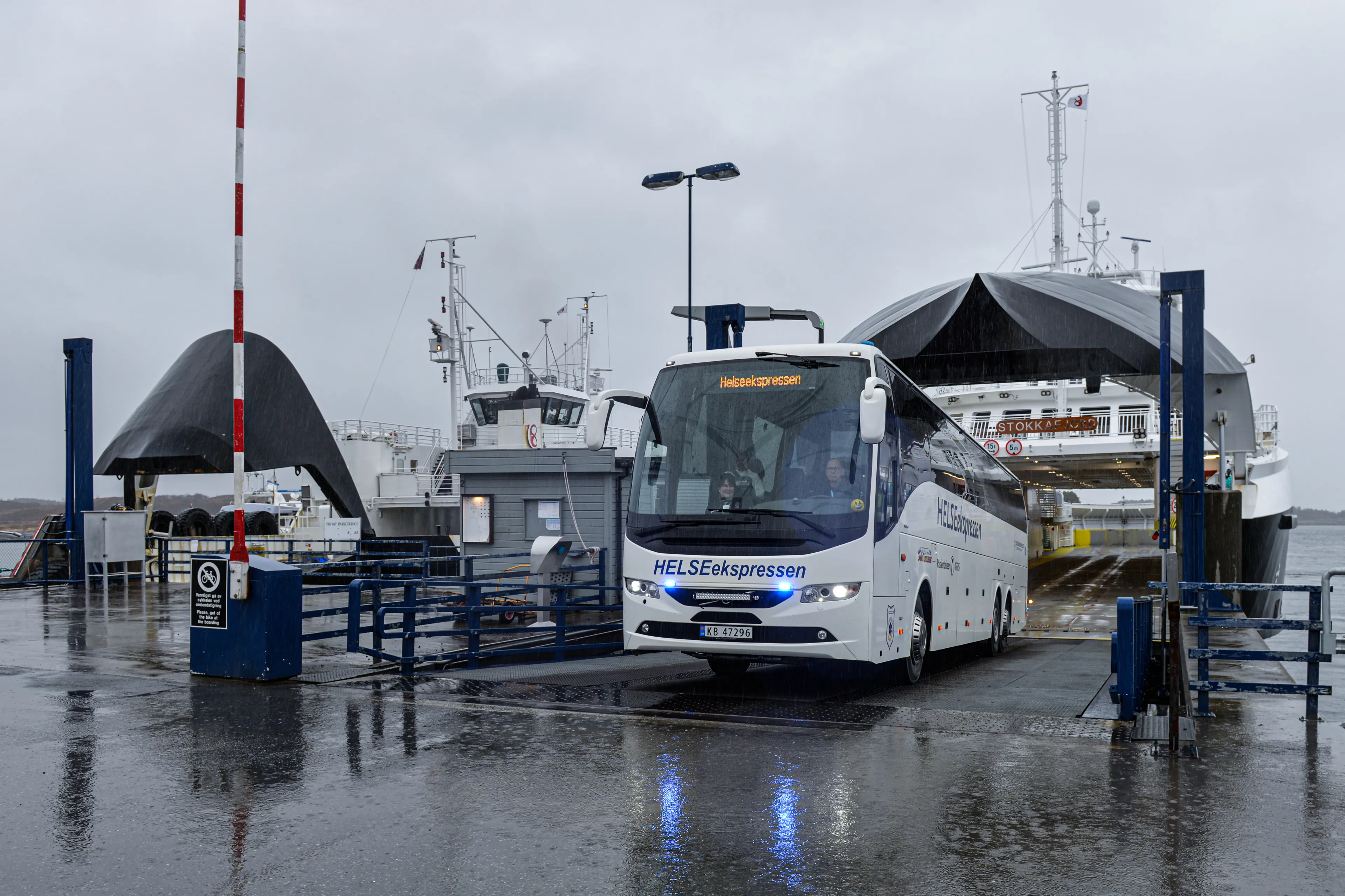 Buss kjører av ferga med blålys på
