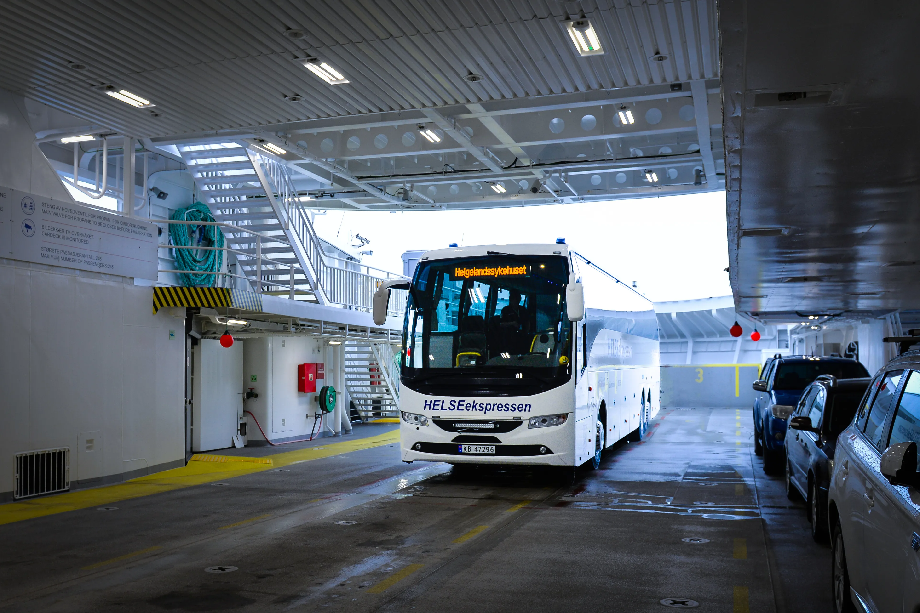 Hvit buss om bord i ei ferge
