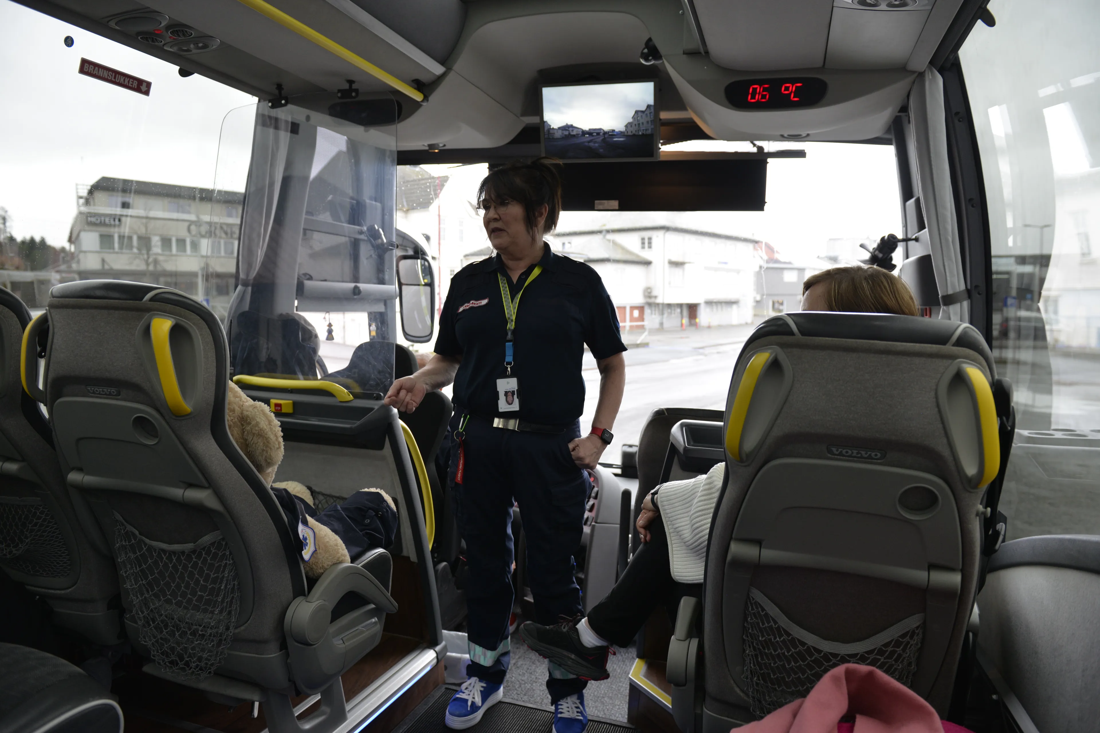 En dame står i midtgangen på en buss