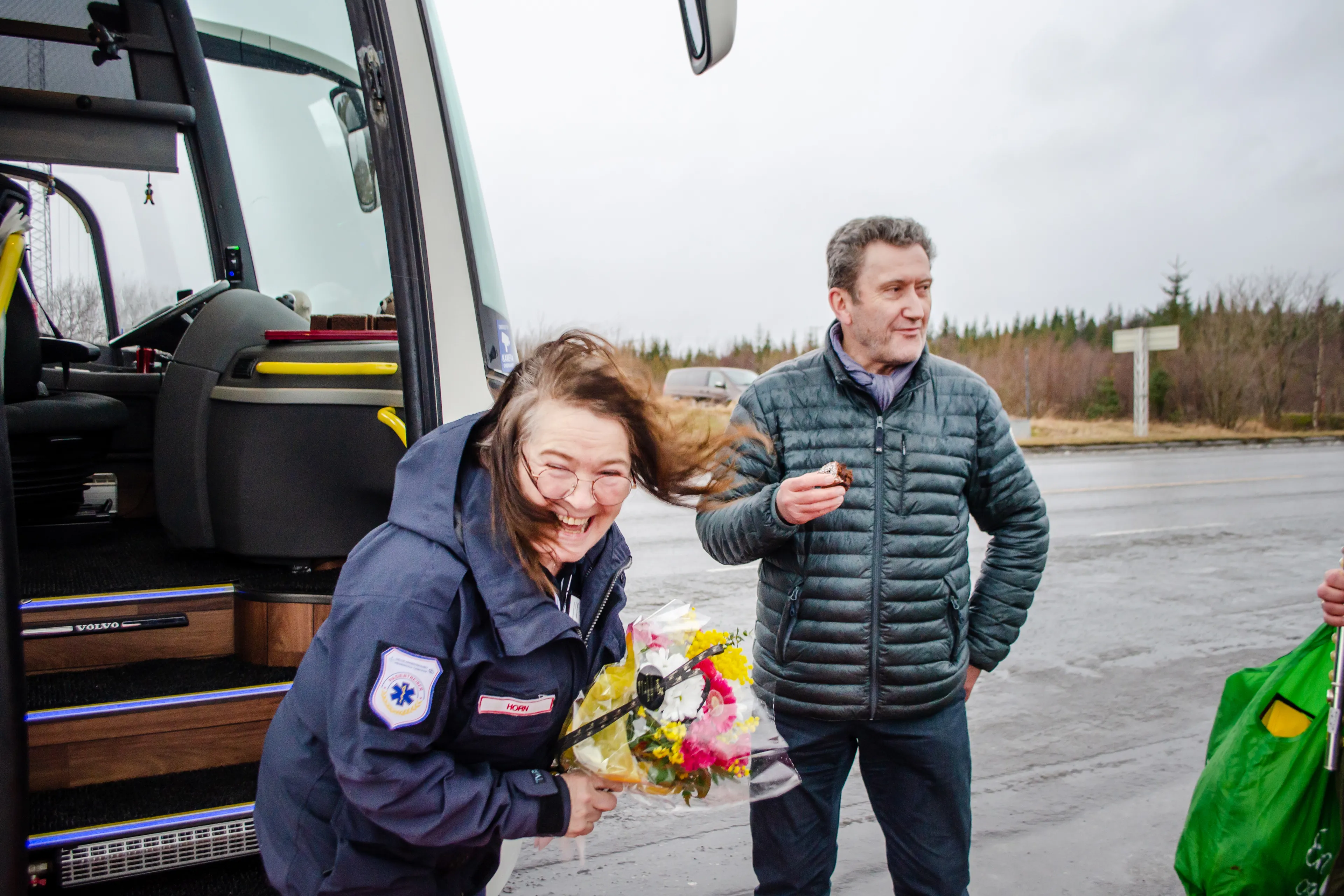 Dame holder blomster mens håret flyr i vinden