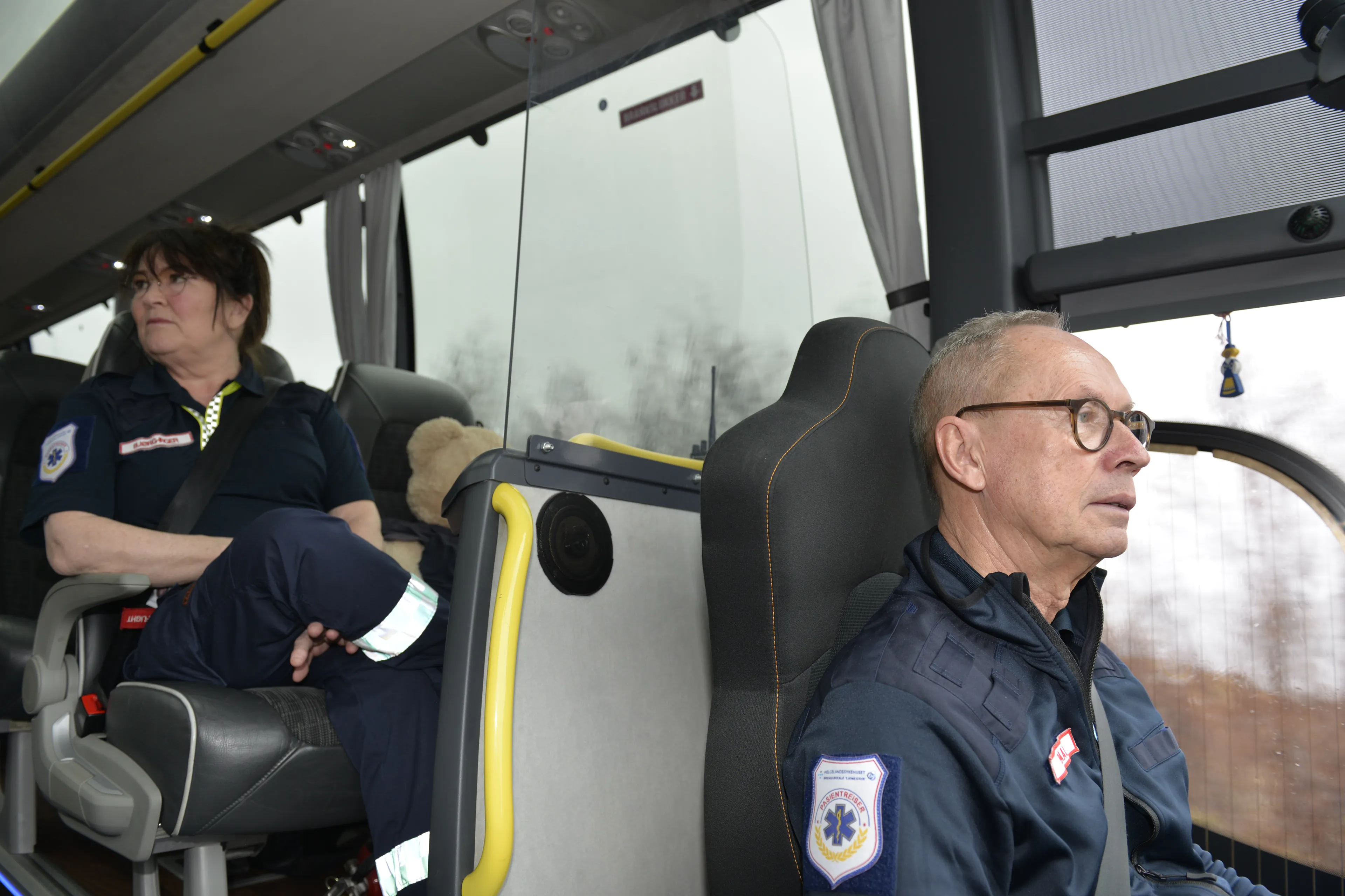 To personer i uniform sitter på en buss