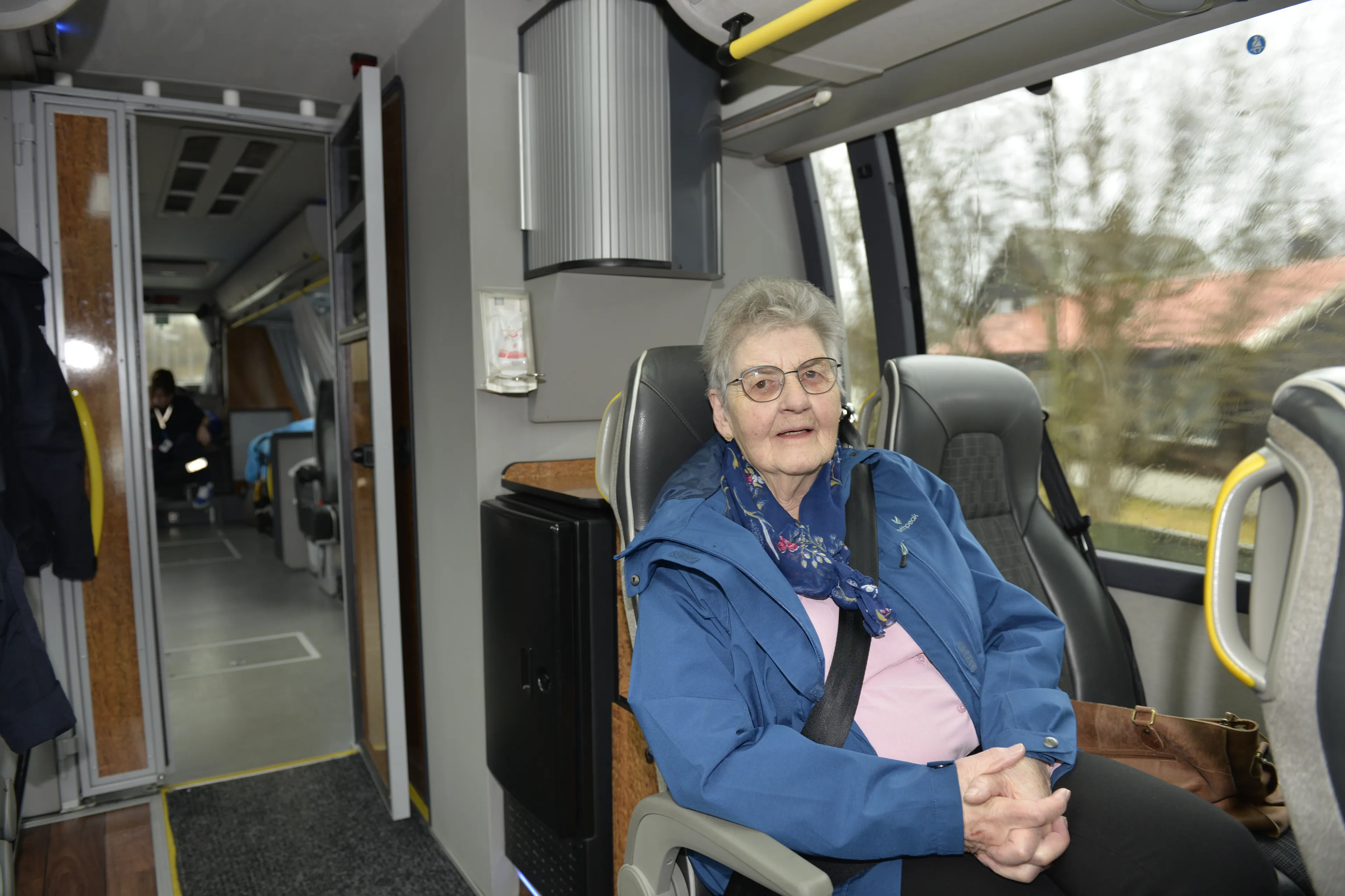 Dame sitter i setet på en buss