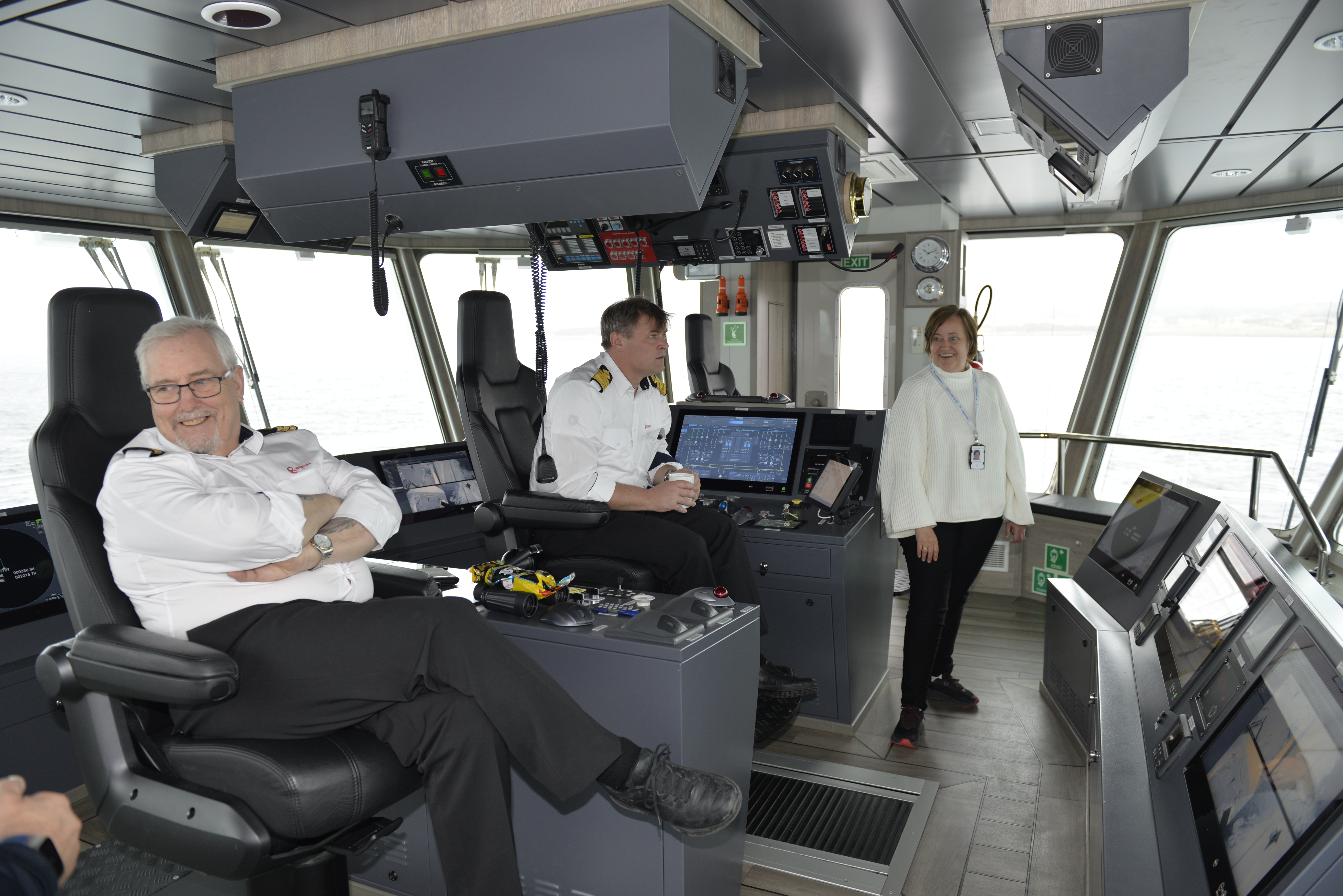 To menn i hvite skjorter styrer skuta