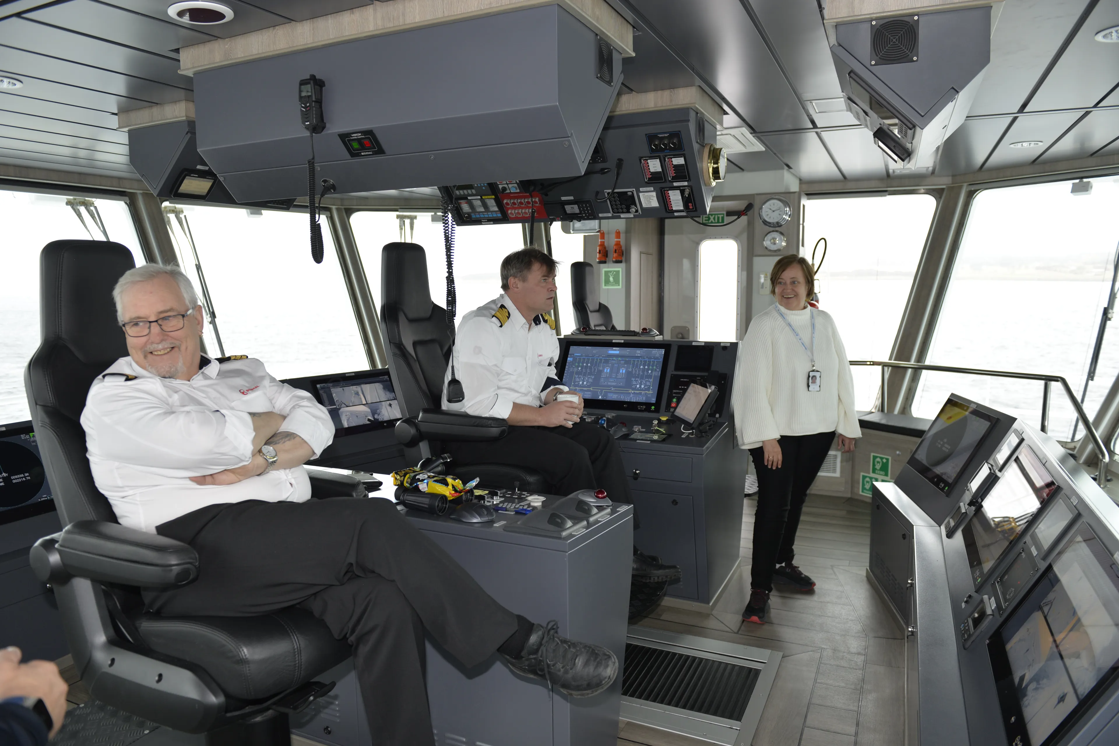 To menn i hvite skjorter styrer skuta