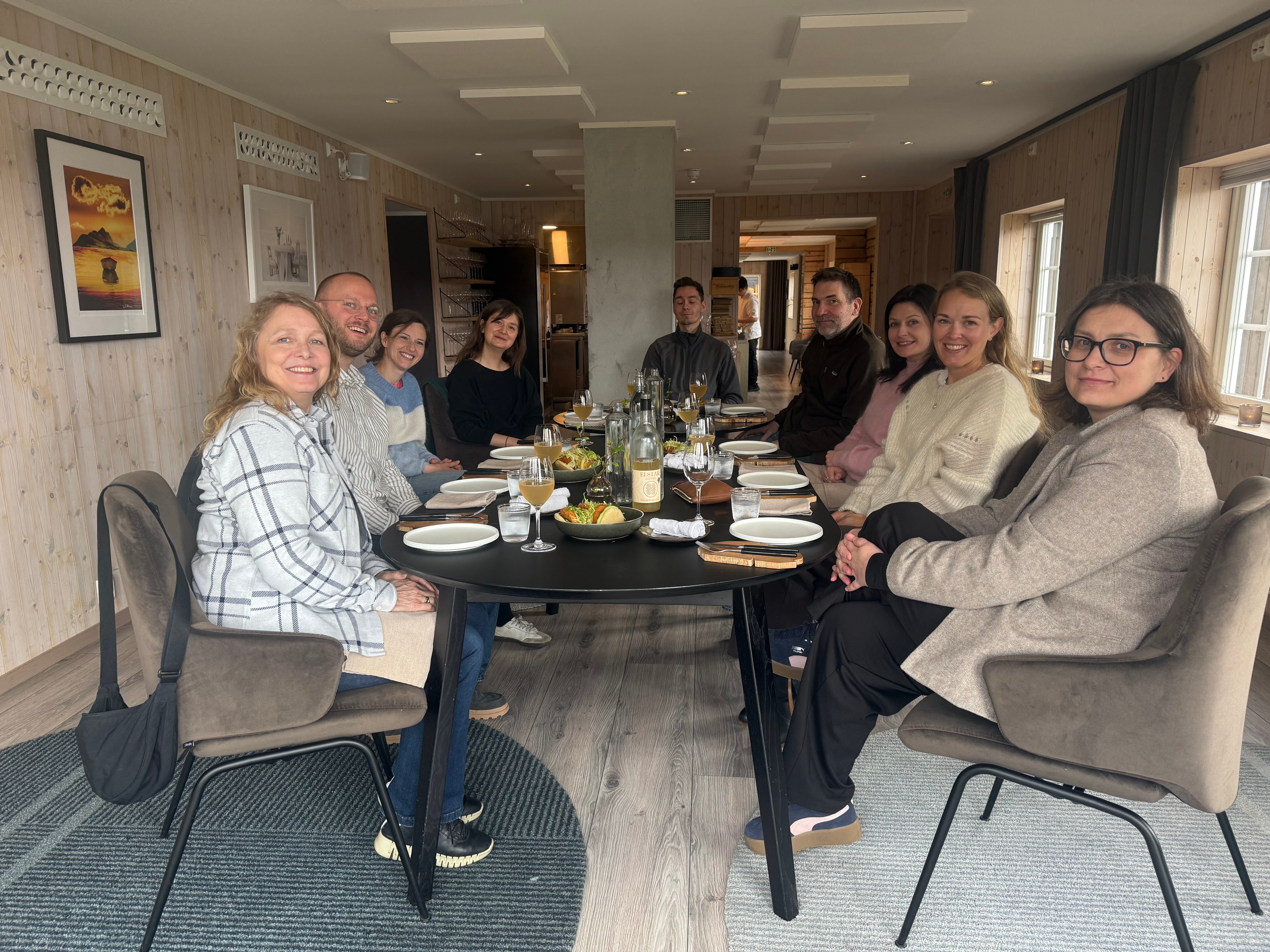 Mange mennesker sitter mamlet rundt et middagsbord