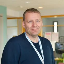 En mann iført blå jakke