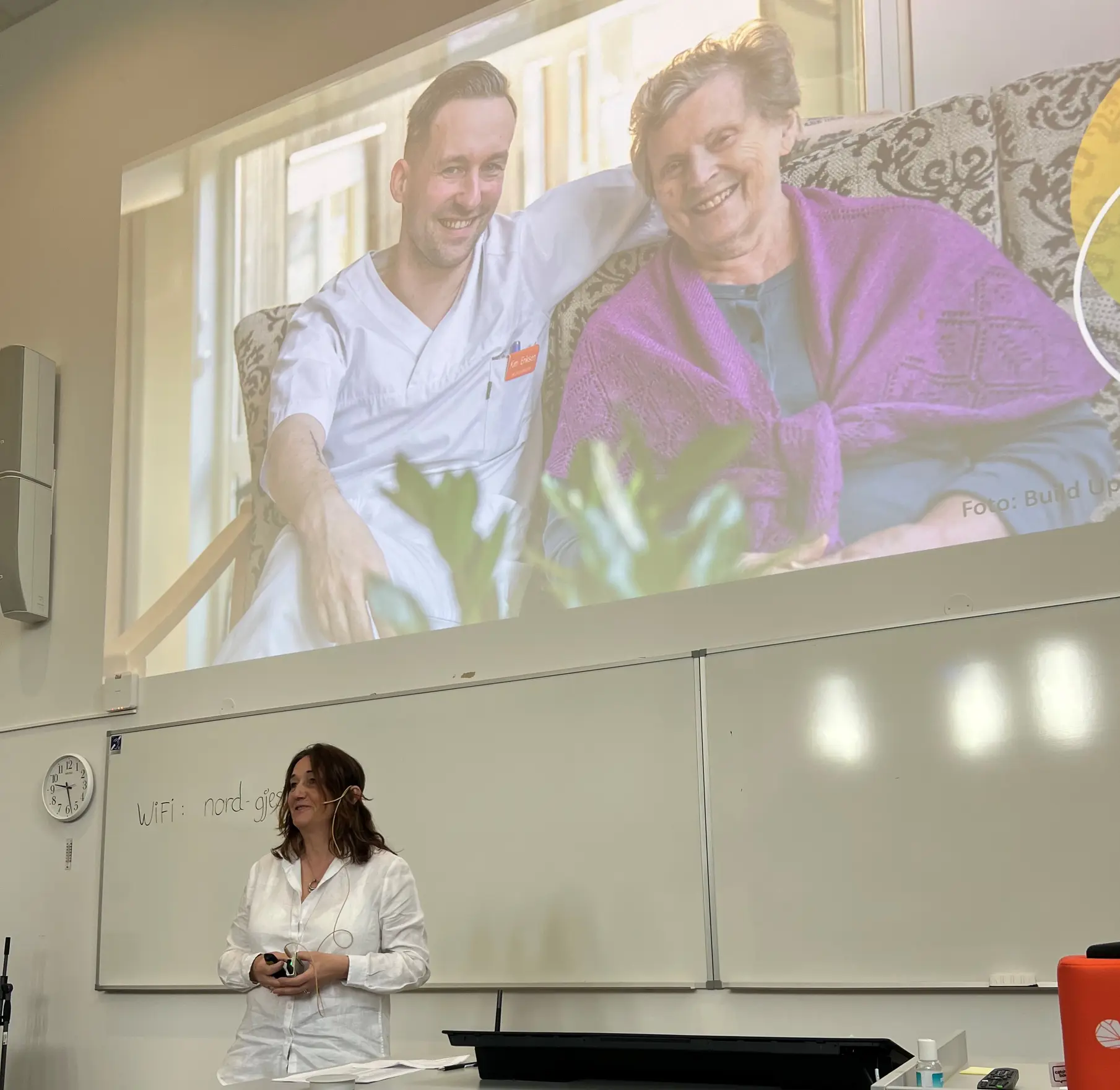 En kvinne står foran en tavle