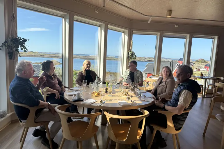 En gruppe personer sitter rundt et spisebord