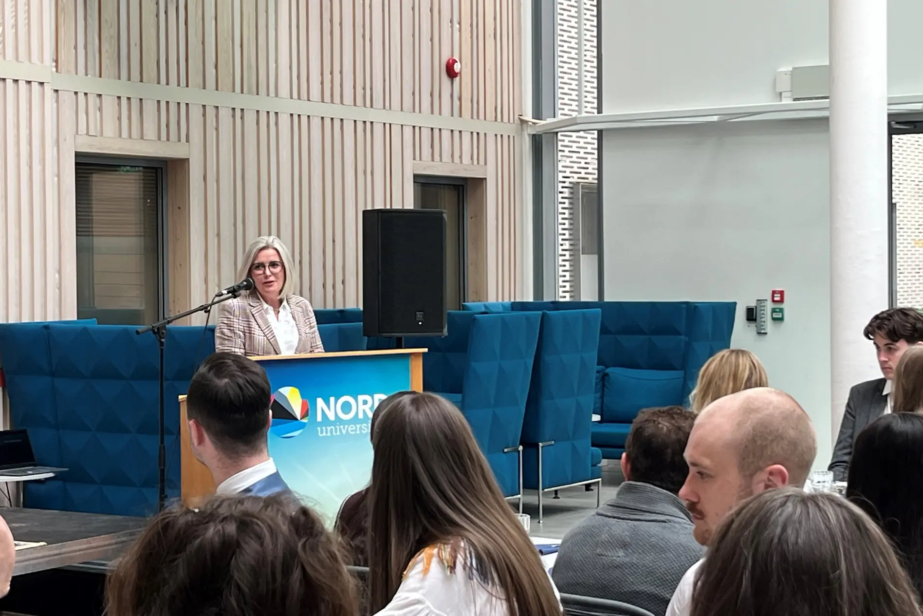 En person som snakker til en gruppe mennesker