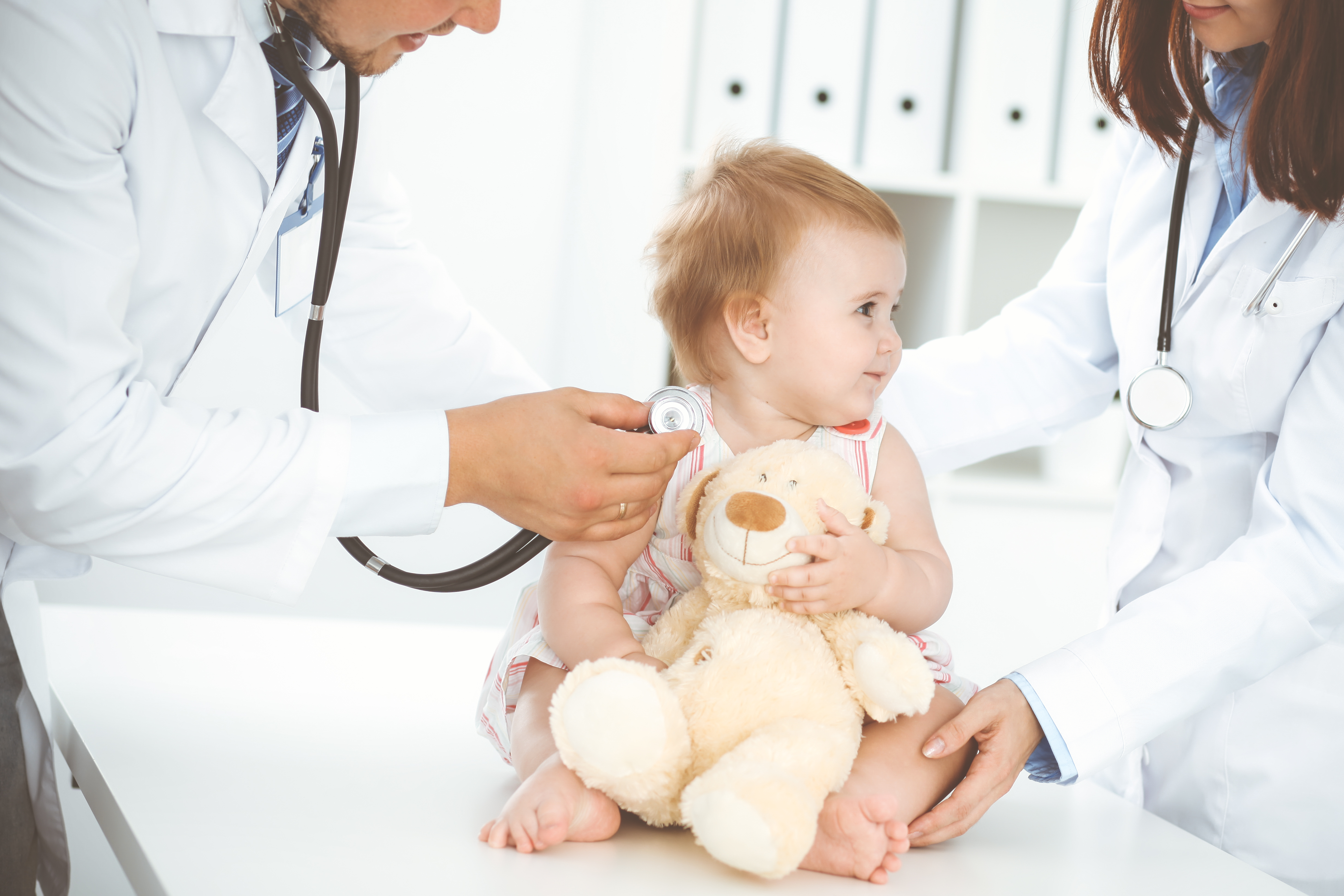 Et lite barn sitter på en behandlingsbenk