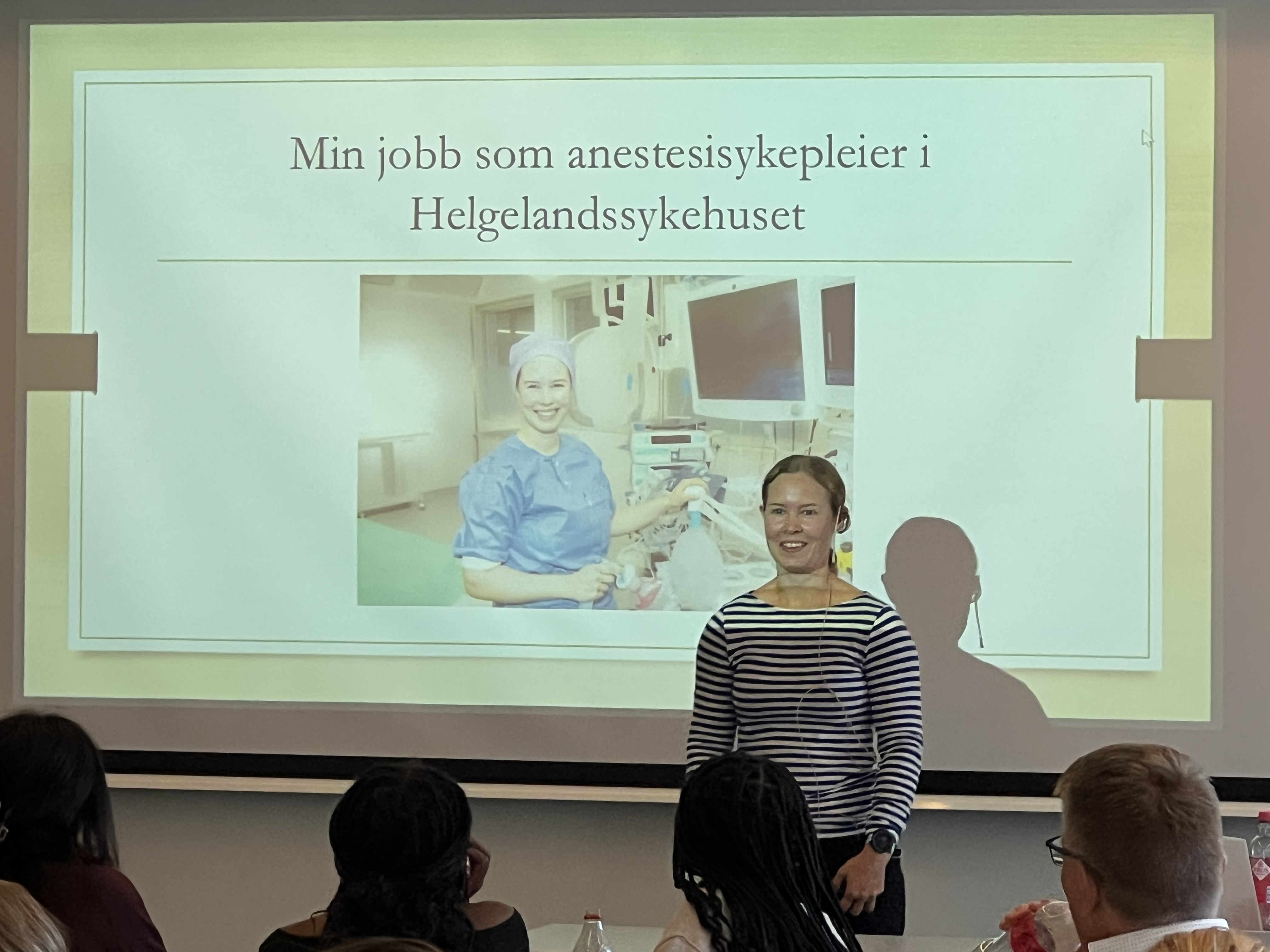 En kvinne som står foran et projektorlerret