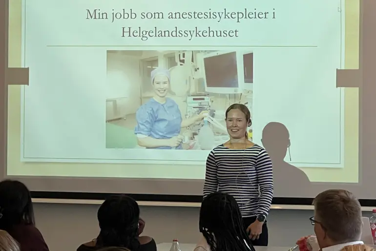 En kvinne som står foran et projektorlerret
