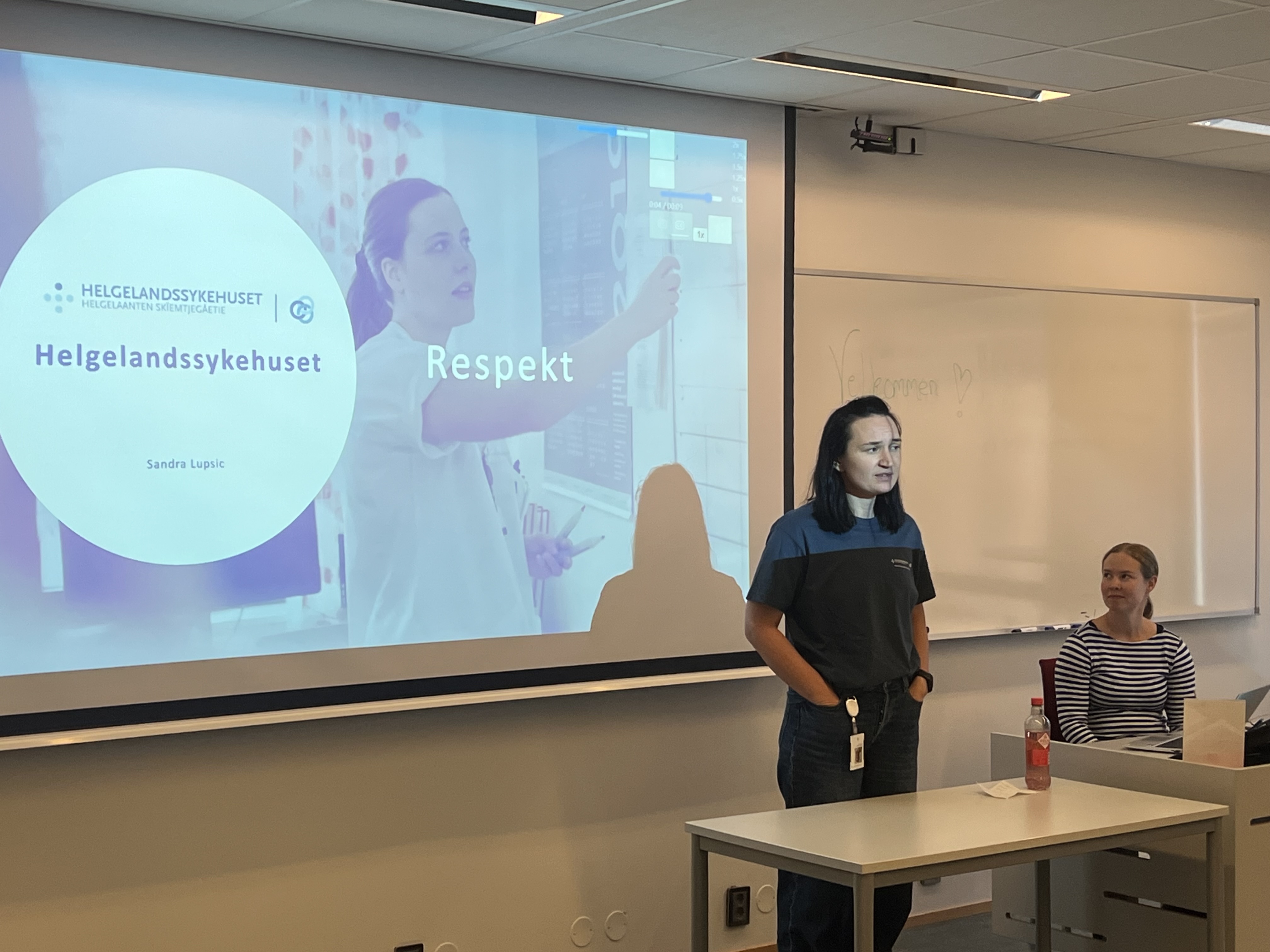 En dame som står foran et projektorlerret