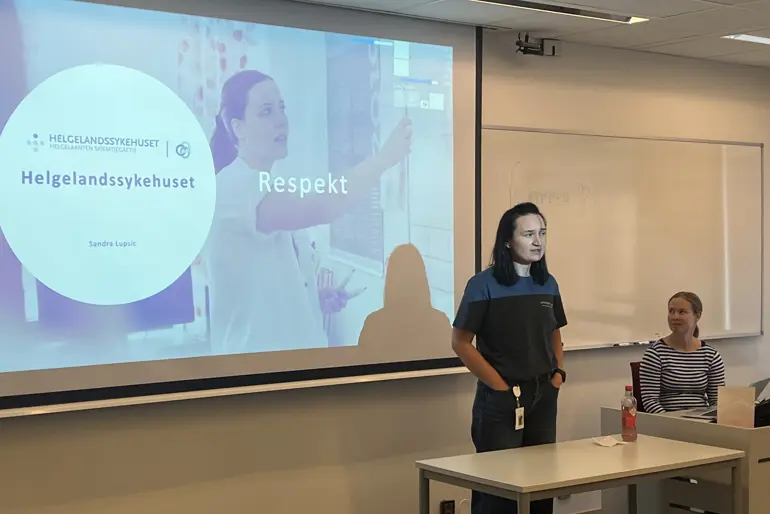 En dame som står foran et projektorlerret