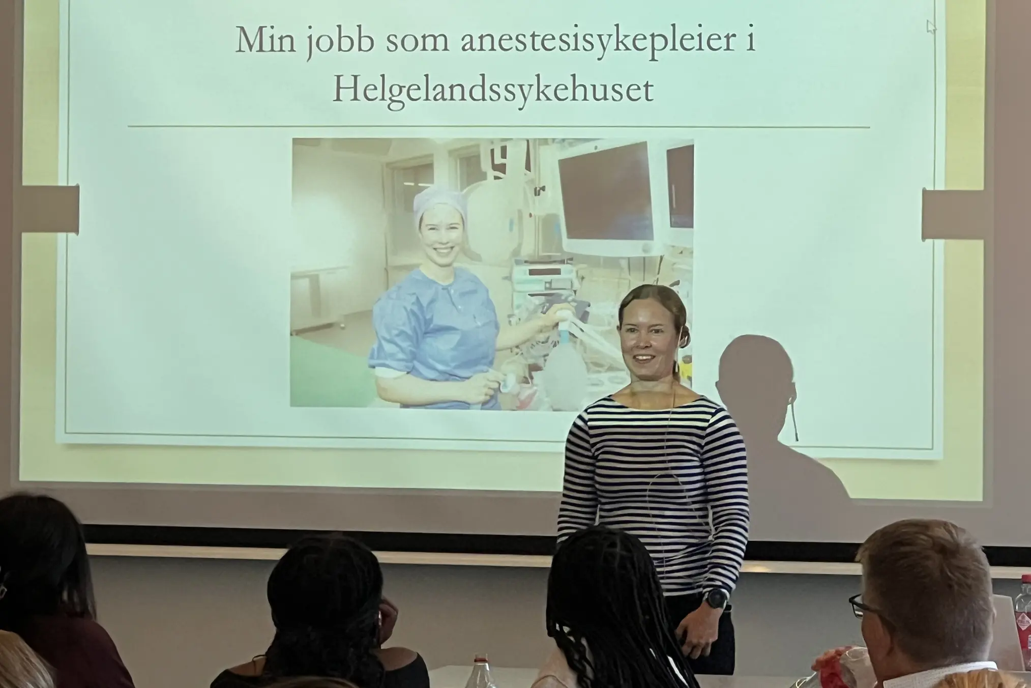 En kvinne som står foran et projektorlerret