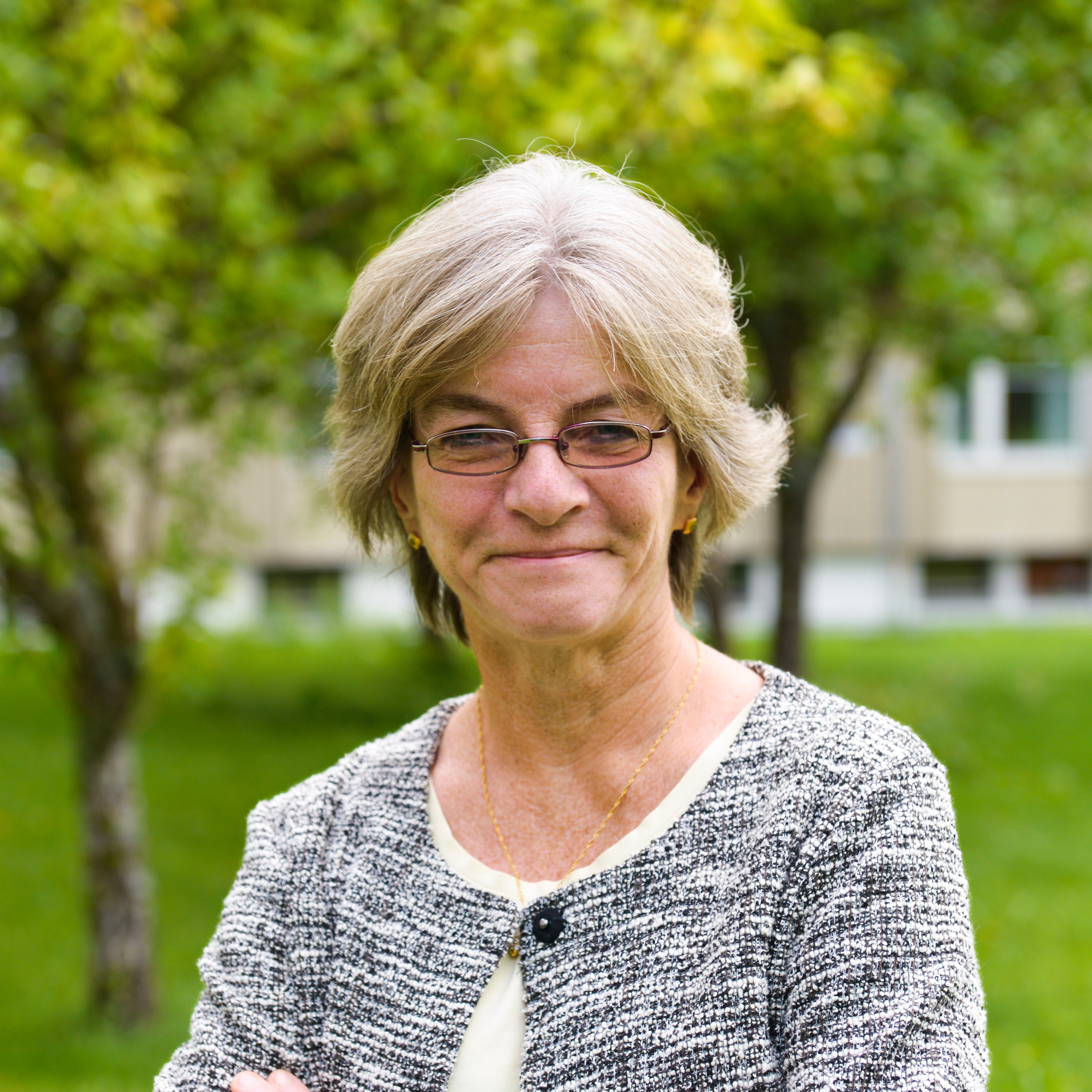 En smilende person med briller