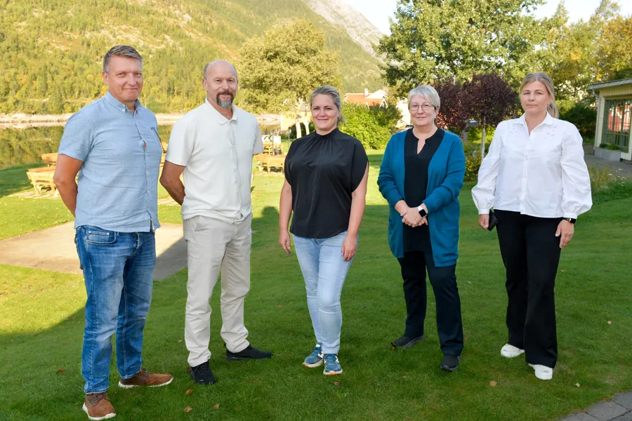 Fem personer som står oppstilt for et bilde