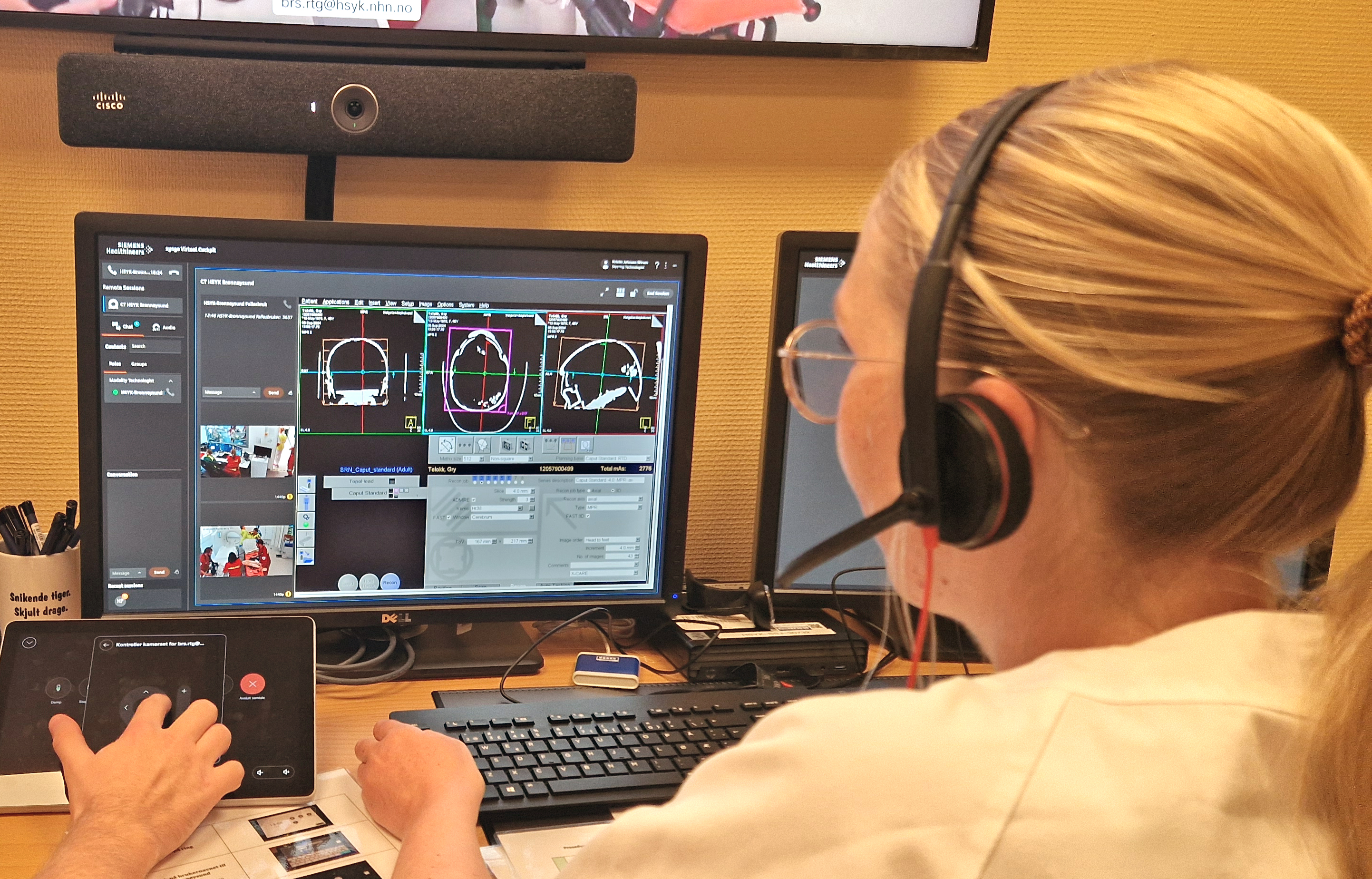 En person som har på seg hodetelefoner og sitter ved en datamaskin