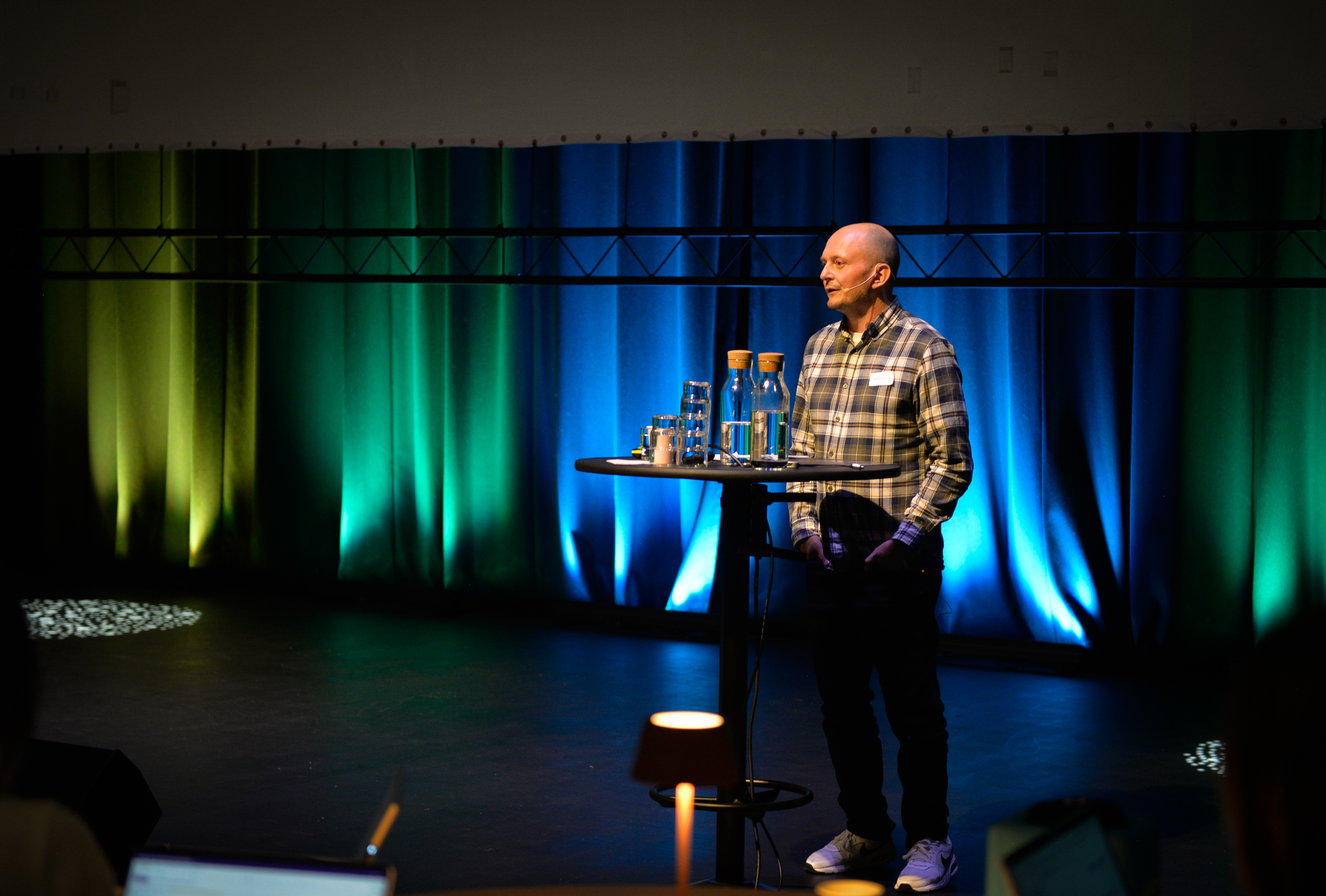 En mann som står på en scene og snakker i en mikrofon